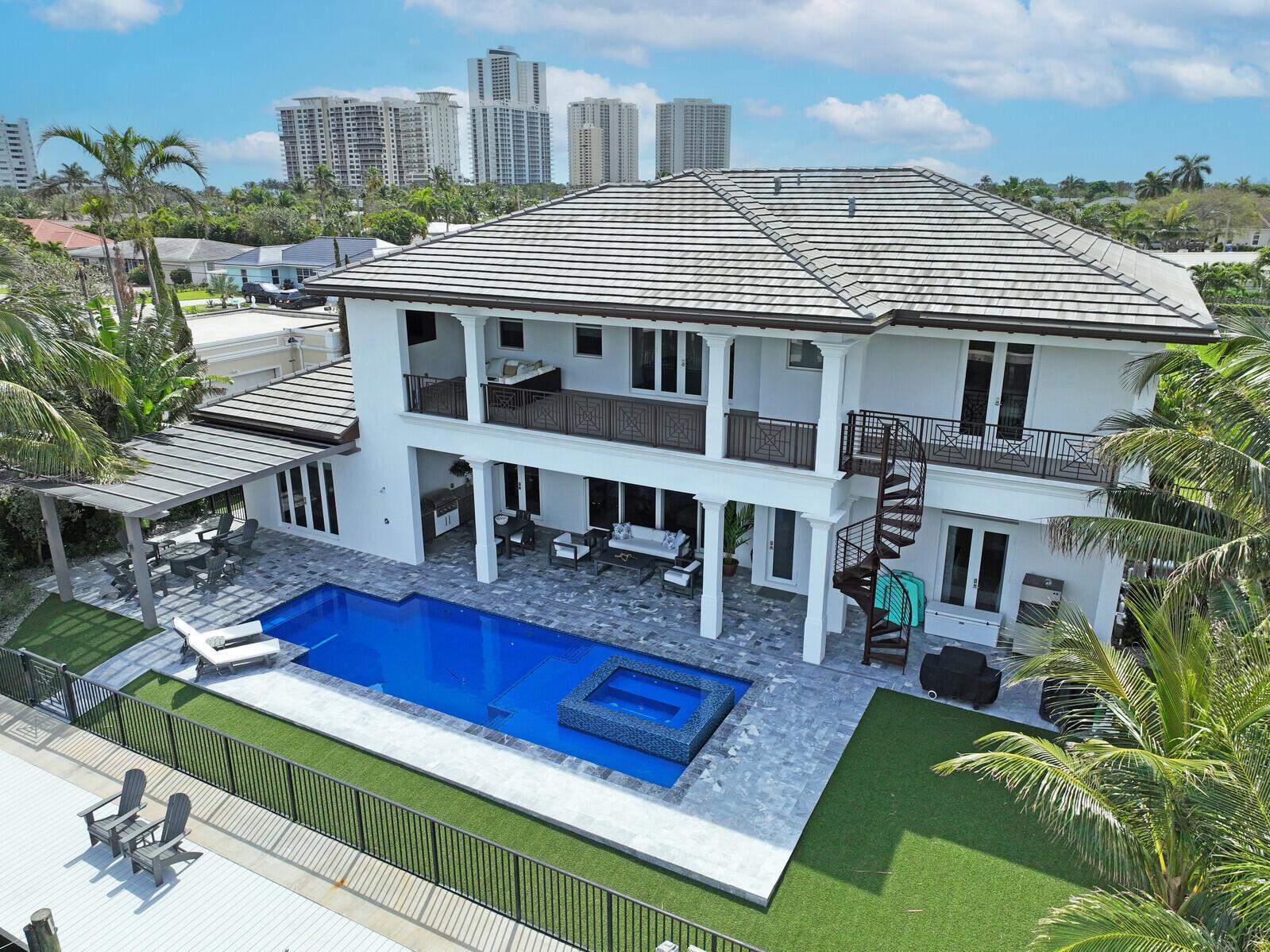 Built in 2019, this upgraded home sits on an expansive 11,000 sq ft intracoastal waterfront lot, fulfilling every boater's or water enthusiast's fantasy with 100' of waterfrontage, perfect for up to an 80' yacht thanks to the deep water and wide channel. Nestled on Bimini Lane, homes here offer deeded beach access. Step through grand oversized entry doors into a realm of opulence across an open floor plan. Gaze through rear sliding glass doors to behold your dream water vista beyond the pool and vanishing edge spa. This home boasts over 4,200 sq ft of AC living space and over 6,000 sq ft of total area, featuring 5 large BR'S and 5.5 BA'S. The first floor encompasses a master suite, formal dining area, laundry room, powder bath, and a private cabana suite with a large covered lanai. Ascend to the second floor via stairs or private elevator to find a secondary master suite, wet bar area, two guest suites, a media loft, covered lanai, and washer/dryer unit. Craftsmanship shines with high-end plumbing and electrical fixtures, a Sub-zero appliance package including an oversized refrigerator and natural gas cooktop in the kitchen. Revel in outdoor gatherings with the outdoor kitchen and natural gas grill. Full house generator! Experience award-winning craftsmanship and transform this residence into your personal sanctuary. Singer Island beckons as paradise awaits your arrival.