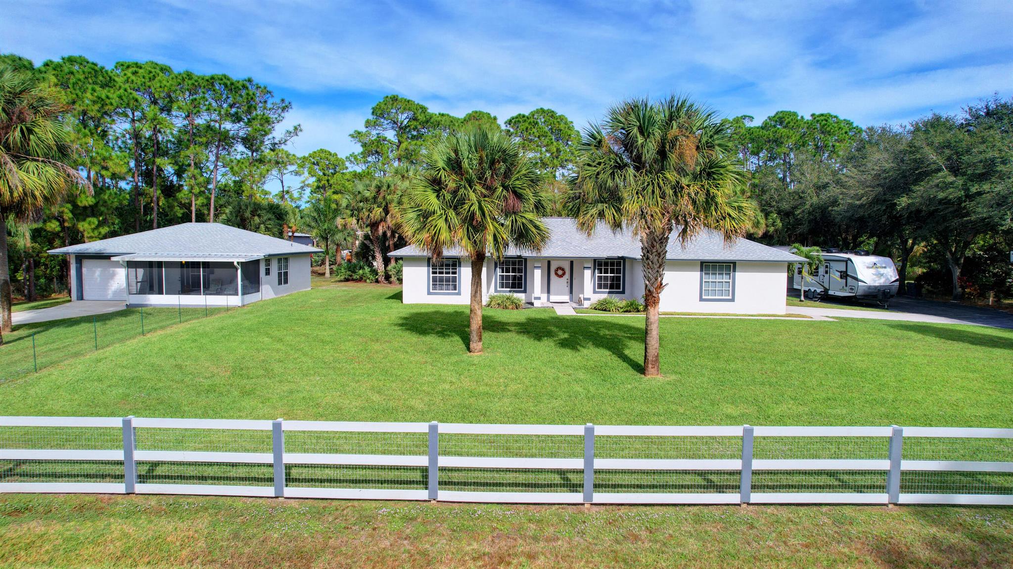 Welcome to this stunning 2 home equestrian estate, (new roofs 2023) boasting a beautifully designed main house and a charming guest house perfect for accommodating in-laws or guests. The property is adorned with exquisite features and modern amenities, providing comfort and luxury. The main house, constructed in 2005 and offers an updated ambiance. Featuring a 2017-installed AC unit, sealed ducts, and recently upgraded wood cabinets with double sided base and pull-out organizers. This residence boasts a contemporary Quartzite waterfall, a true centerpiece added in 2023. LED lighting throughout the house illuminates its elegant interior. Meanwhile, the 1999 guest house presents a cozy retreat with a new water heater and recent updates. With LED lighting and a 1.5-ton AC unit, this dwelling ensures comfort and efficiency. Both houses enjoy the convenience of a shared irrigation system comprising 12 zones, providing lush greenery and maintaining a picturesque landscape, complete with lush landscape for residents to relish. Outdoor entertainment is a delight with a crushed granite fire pit area, a screened enclosure, and a charming gazebo, perfect for gathering and relaxation. In addition the tack room, paddock and wash rack make this an equestrian paradise. The property also includes a detached steel building, featuring a 200-square-foot garage, 400-square-foot carport, and an additional 200-square-foot side space, offering ample room for storage or customization to suit various needs. Furthermore, this estate is equipped with a single septic system serving both houses, ensuring efficient waste management and ease of maintenance. Experience the essence of luxurious country living in this meticulously maintained equestrian estate, offering unparalleled comfort, modern amenities, and a serene ambiance for its fortunate resident