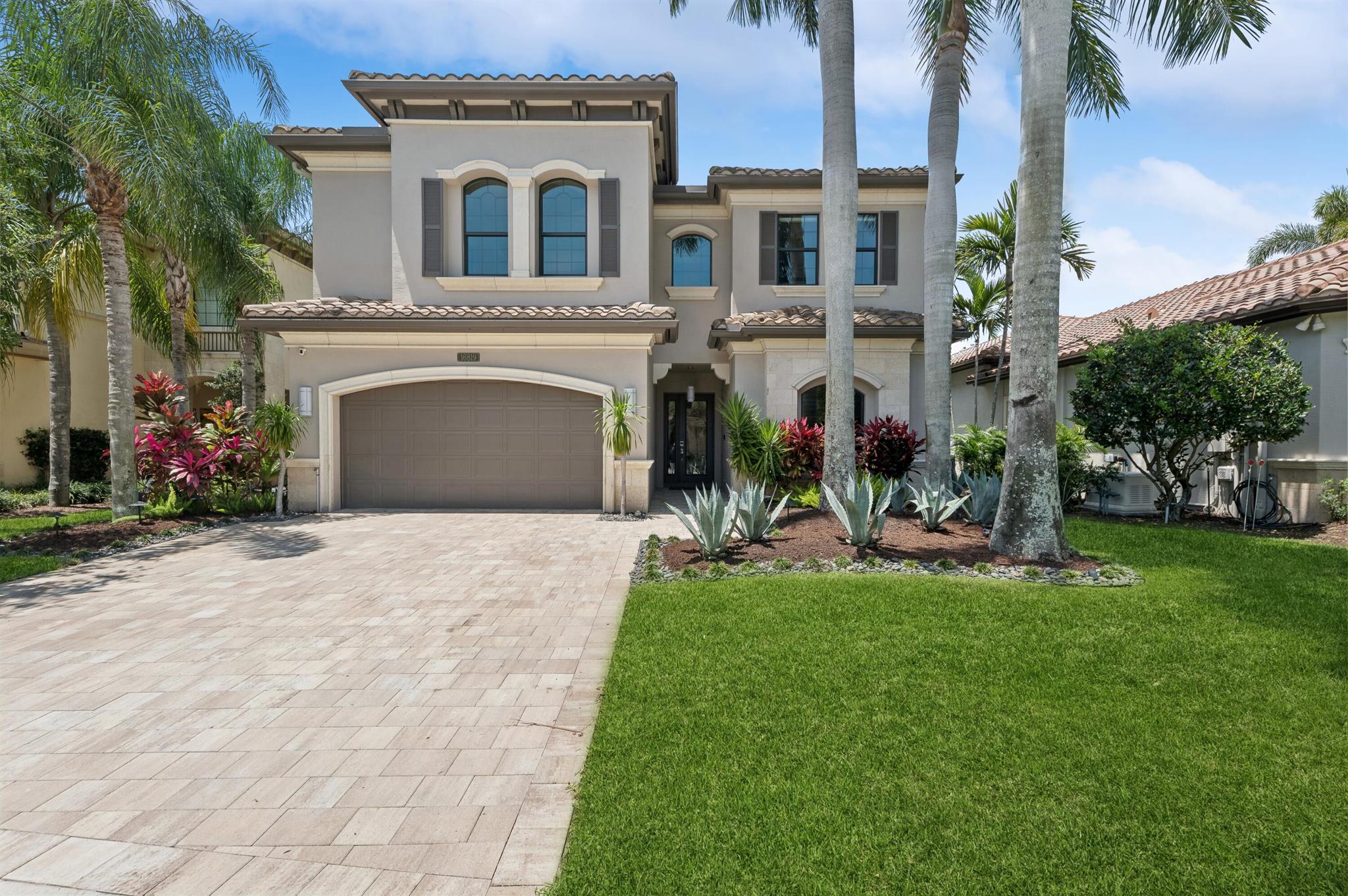 Discover refined elegance in this stunning turn-key model home. The breathtaking living room boasts a floor-to-ceiling stone, tile, and wood accent wall with a grand fireplace. The gourmet kitchen is a chef's paradise with 42' wood and glass cabinets, upgraded Caesarstone countertops, and top-of-the-line stainless steel appliances. The luxurious master suite features a coffered ceiling, custom walk-in closets, and a spa-like bathroom. Impeccable design details include custom moldings, a wet bar, and a butler's pantry. Outside, a raised spa, modern pool, and serene lake view await. Experience unparalleled luxury and sophistication in this forever home.