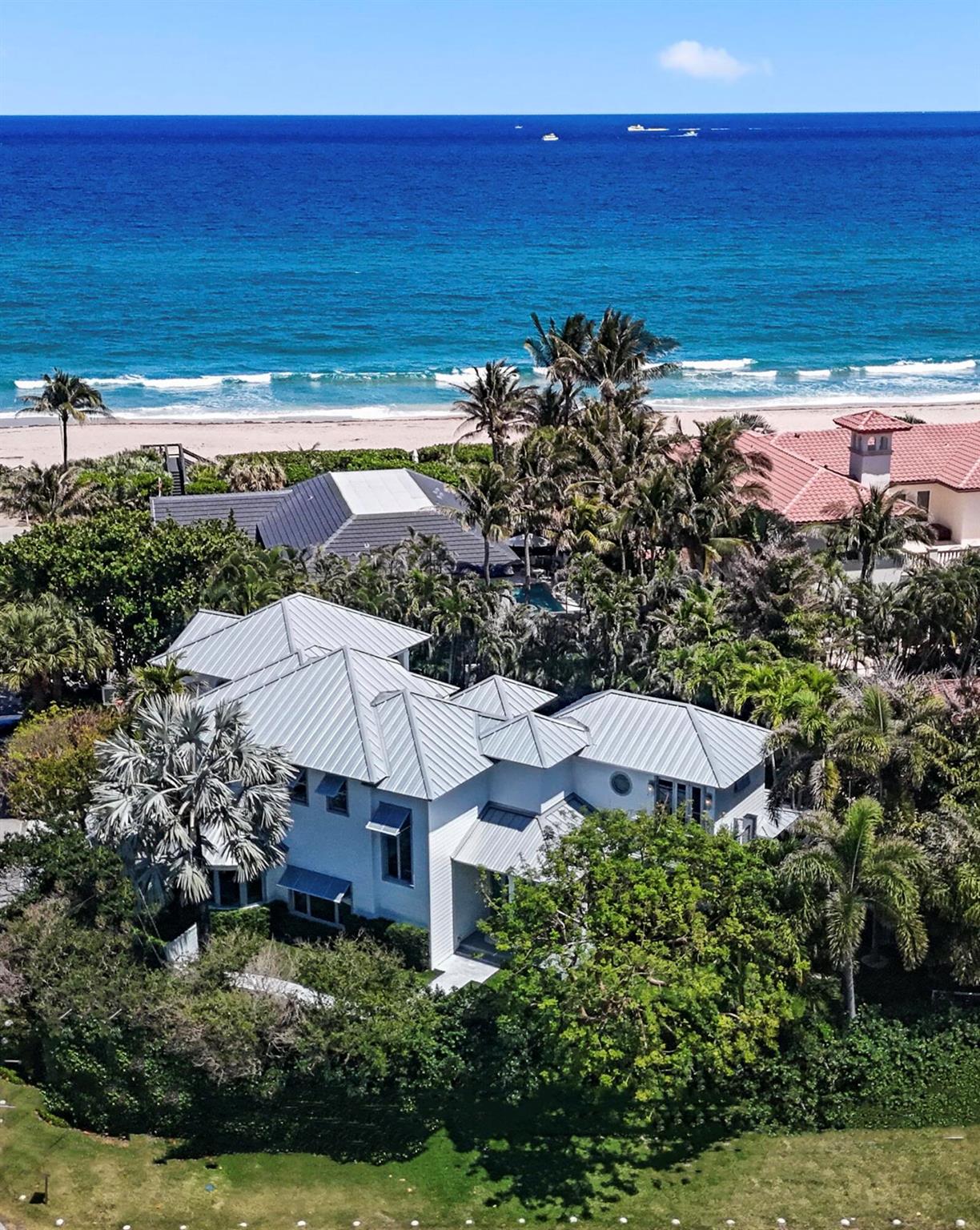 A rare oceanfront opportunity awaits!  Nestled on nearly 1/2 an acre in the highly desirable and quaint seaside town of Ocean Ridge, and located just minutes from Palm Beach and Downtown Delray, this truly turnkey transitional coastal modern home boasts ocean views and over 50ft of private beach space including your own large dune deck.  No expense was spared in the full gut renovation of this stunning home. As you enter the gated property and walk along the winding pathway, you can hear the sounds of the ocean, smell the saltwater in the air, and feel the sense of tranquility that comes from the private, spacious, tropical yard.  As you enter the home, you are immediately struck by the soaring vaulted ceilings and walls of glass creating a bright and airy sanctuary. The new white oak floors that run throughout as well as the fresh white paint and designer fixtures underscore the luxury beachside feel of the home. The open living and formal dining room lead into a completely remodeled eat-in chef's kitchen boasting solid wood custom cabinetry, quartz countertops, a 6 burner gas cooktop, new Miele dishwasher and coffee machine, a new high-speed Miele oven, and a newly built out walk in pantry with two Sub Zero wine refrigerators and freezer.  The kitchen and living room open onto the fully fenced in tropical backyard oasis which includes a large covered patio, brand new heated saltwater pool and spa, summer kitchen, outdoor shower, and grass turf. Both of the oversized main-floor bedrooms enjoy spacious built-out closets and generous natural light, with one of the bedrooms boasting a completely renovated ensuite bathroom with quartz countertops and designer tile. The striking stairway leads to the sunny second floor where you will find the primary suite and an additional bedroom with ensuite bath, ocean views, and a private balcony.  The master suite is a truly elevated and luxurious retreat with its own wraparound veranda, separate sitting area, an expansive built-out walk-in closet, and a designer bathroom to rival even the highest end hotel spas.  The spacious 3-car garage offers ample storage and includes a newly installed lift for automobile collectors. Enjoy the very best of oceanfront living whether it's from your gorgeous new home, the tropical oasis grounds, or the private beach just steps from your front door!