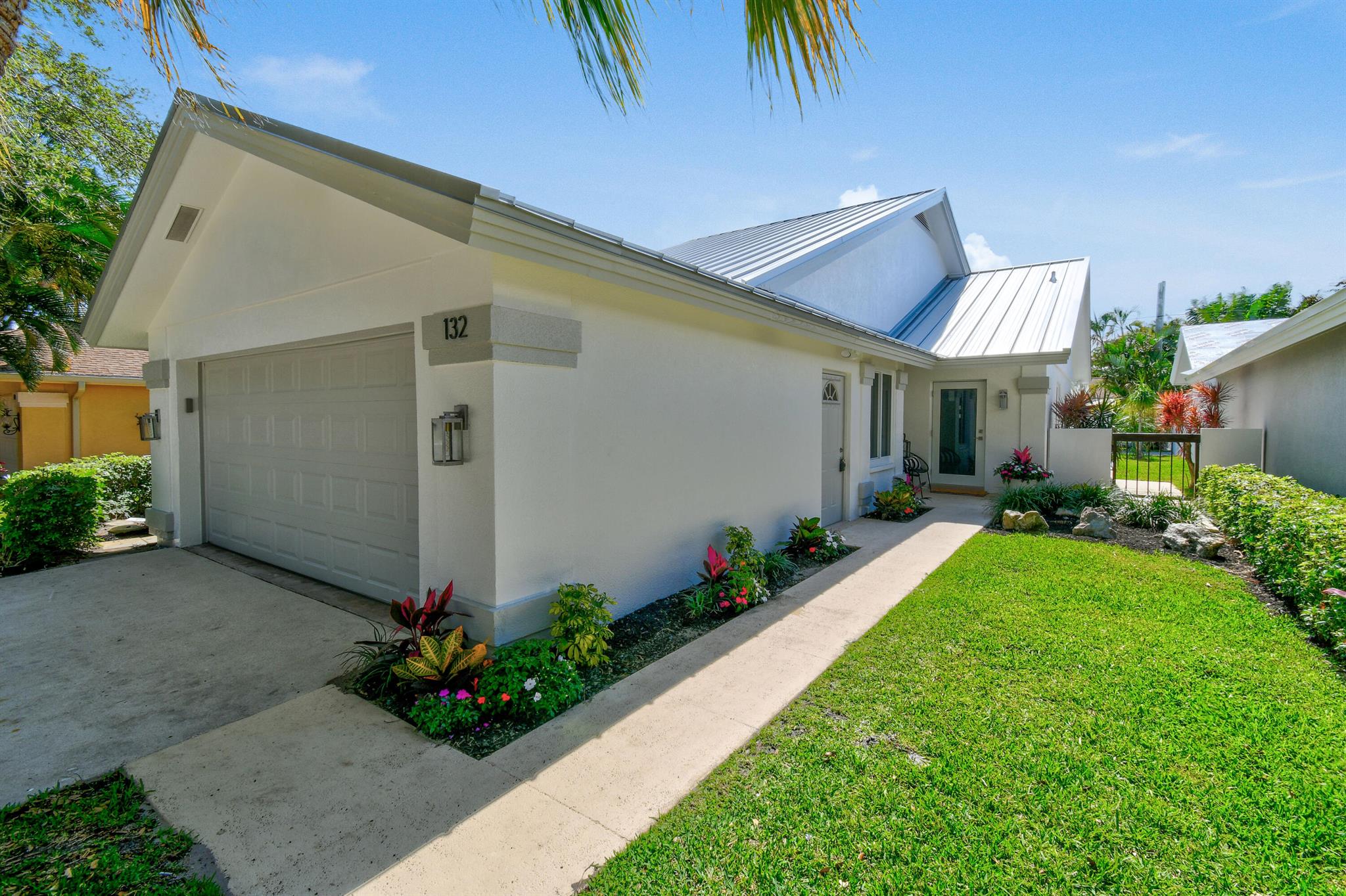 Welcome to Jupiter Beach Paradise! You will fall in love with this completely RENOVATED Bluffs home the moment you arrive. Upgrades include a NEW METAL ROOF, new landscaping, resurfaced renovated pool, All new IMPACT sliders, front door, and windows (garage side door is not impact). The kitchen adorns new stainless appl, white shaker cabinets, and quartz counters, porcelain wood look floor tiles throughout. All bathrooms have been completely renovated. The primary has a free standing tub with separate shower and marble flooring.The home has been painted inside/and out with new 6'' baseboards, new shaker doors and smooth  ceilings. You will also find all new light fixtures, fans, and washer/dryer. Walking distance to the Jupiter/Juno Beach, restaurants