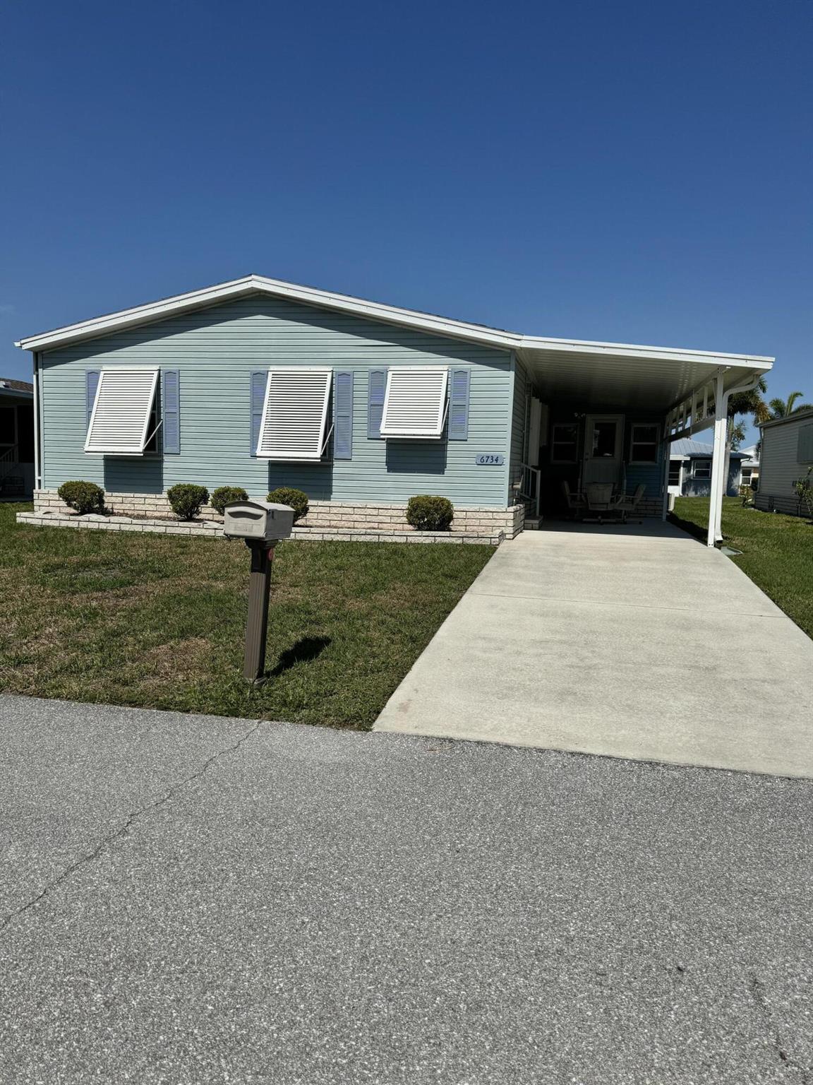 Must See! Very well kept lovely 2 bedroom 2 bath home with remodeled  Florida room. Florida room has been fully enclosed with hurricane windows, mini a/c unit with heat. Can be used as 3rd bedroom. Home has all new laminate flooring throughout. No carpet. Split floor plan. A/C is 2018. Water heater is 2021. Washer and Dryer is 2021. New appliances in kitchen. New king bed in Primary bedroom. New fans in bedrooms. Home is being sold furnished. Home has a lovely sitting area with table and chairs in carport. as well as a shed in back of home and big backyard. Spanish Lakes is 55+ community. Private 18 hole golf course, 2 pools, pickle ball, tennis, shuffleboard, bocce, gym, library, wood workshop and much more.
