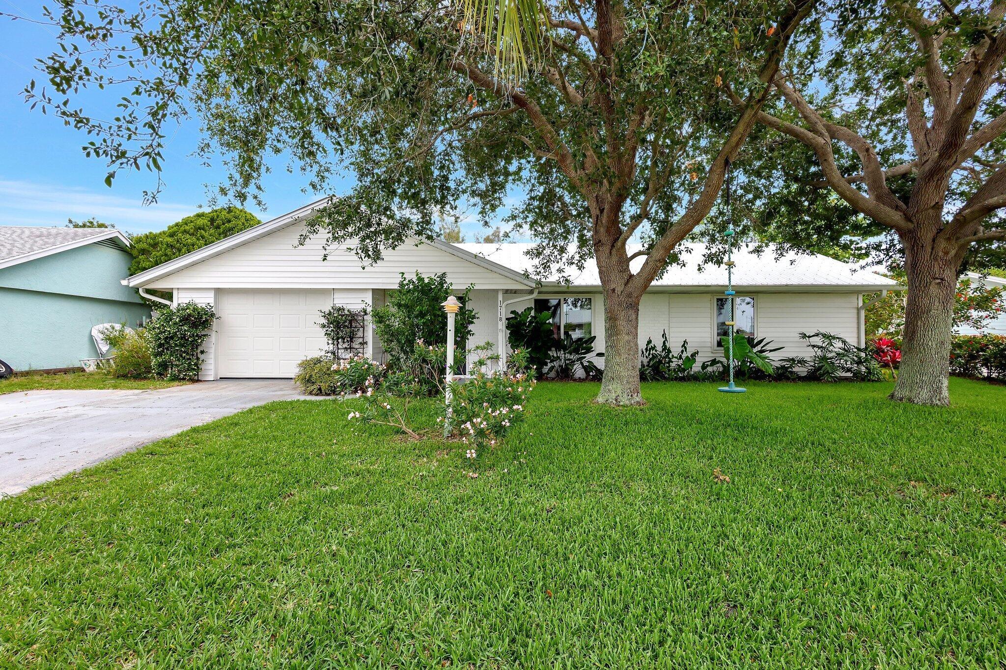 Leilani Heights Charmer in the heart of Jensen Beach. 3/2 single family home with 1 car garage. Complete IMPACT glass and impact doors (2023) plus garage door (2017) for hurricane mitigation credit. Metal roof 2018. A/C 2017.  Great kitchen & bonus family room. Nice sized lot, well landscaped & backs to HOA owned green space. Mostly fenced backyard w/paver patio, kid's fort & shed. Many updates in kitchen, baths, flooring & throughout home. Very nicely maintained.  Home has a split BR plan & all BR's have walk-in closets. Public water & sewer. Sprinklers on well. Full size washer & dryer in garage. Low HOA dues of $150 per year. Community playground area close by. In walking distance to Jensen Beach Elementary. Close to the Beaches, downtown Jensen, mall, dining & more