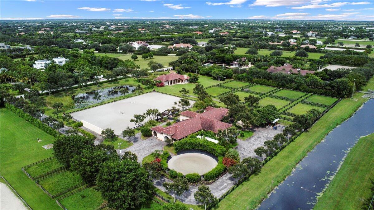 Amazing opportunity to be on the canal side of Sunnyland, TRUE hacking distance to WEF. 12 stalls (all w/rubber mats) available in this 16 stall barn-Landlord will keep 4, and will maintain the ring daily. This stunning barn was built in 2012, and the ring has since been widened, w/the footing upgraded to Martin Collins (fiber/sand mix).  This barn spares nothing - air conditioned tack room, feed room, hay/shavings storage, laundry, studio apartment, powder room - and just wait until your horses see the paddocks!The custom 4 BD/4BA home is just a short walk from the barn, yet still maintains privacy with its own gate, circular driveway, and 2 car garage.  Chef's kitchen, covered patio for a sunset view, split floor plan, perfect for those that need to stay close to the horses