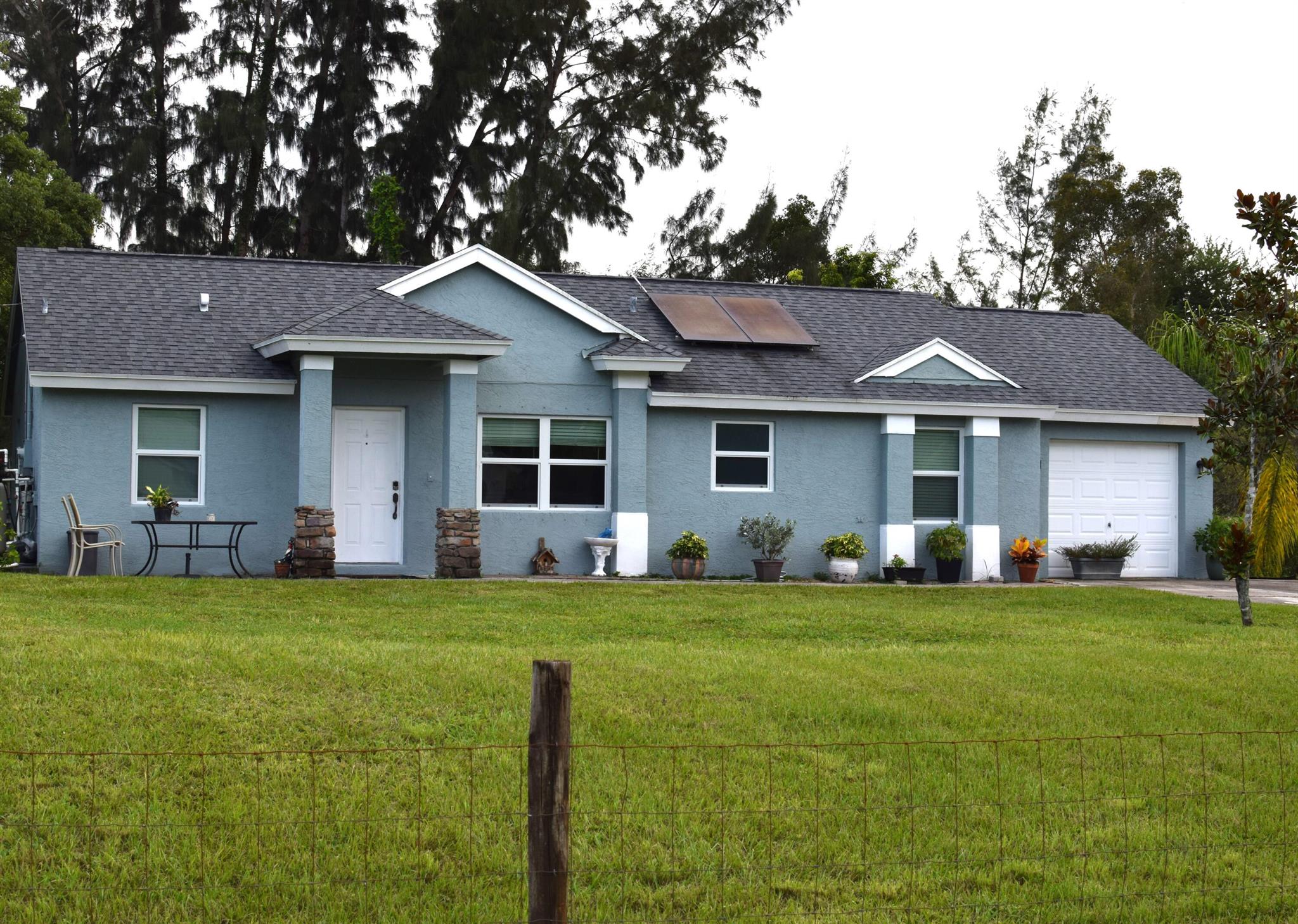 This 3 bed 2 bath ranch-style home is situated on 1.14 acres and offers the cozy feel of the country while being conveniently located near Westlake, Royal Palm Beach, Wellington, and much more! This home's open concept living/dining/kitchen area provides the perfect space for entertaining and socializing. The back French doors allow for opportunities to expand your living space into the lush backyard on those beautiful Florida evenings. The primary suite is located conveniently separate from the 2nd and 3rd bedrooms and 2nd full bath, giving a feeling of privacy for families or when guests come to stay. This home boasts many premium upgrades, including: new roof, new air conditioning unit, new water heater, upgraded LVP flooring, new hurricane/impact windows, french doors, and side garage