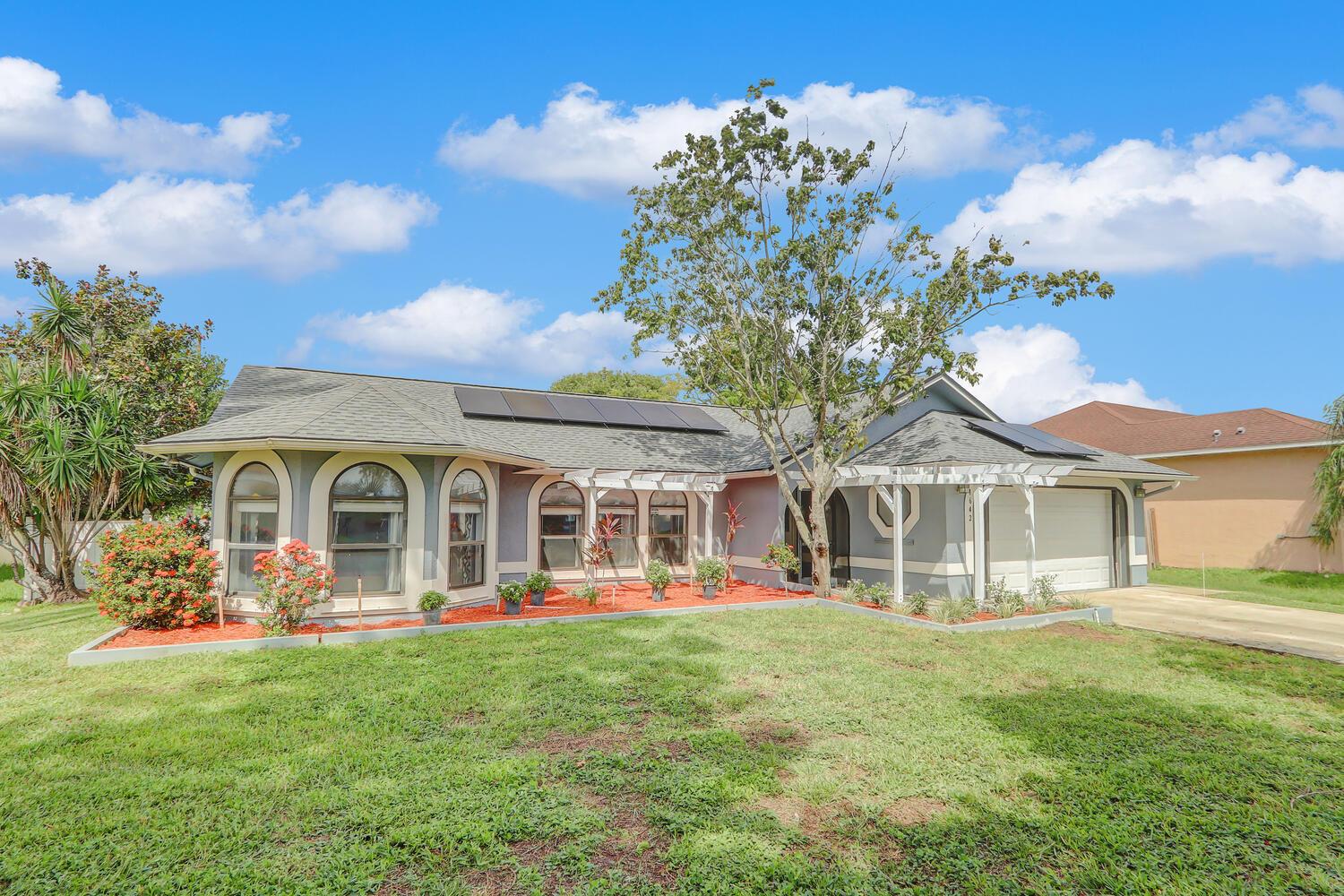 Welcome to this beautifully upgraded 3-bedroom, 2-bath solar energy, pool home with no HOA on a 10,000 sq ft lot in the desirable Fairgreen Crossings neighborhood right next to Tradition but without the fees! Enjoy a brand-new kitchen with custom cabinets, quartz countertops, and a pass-through to the patio. Home boasts new luxury vinyl plank flooring (2022), roof (2022), and paid-off solar panels at closing by seller, ensuring low energy bills. Thoughtful upgrades include custom cabinetry throughout, resurfaced (2024) and re-screened pool, WiFi garage door opener, full metal hurricane shutters including expansive patio, and freshly painted interior. With no carpet, new ceiling fans, and meticulous maintenance, this home is move-in ready for you!