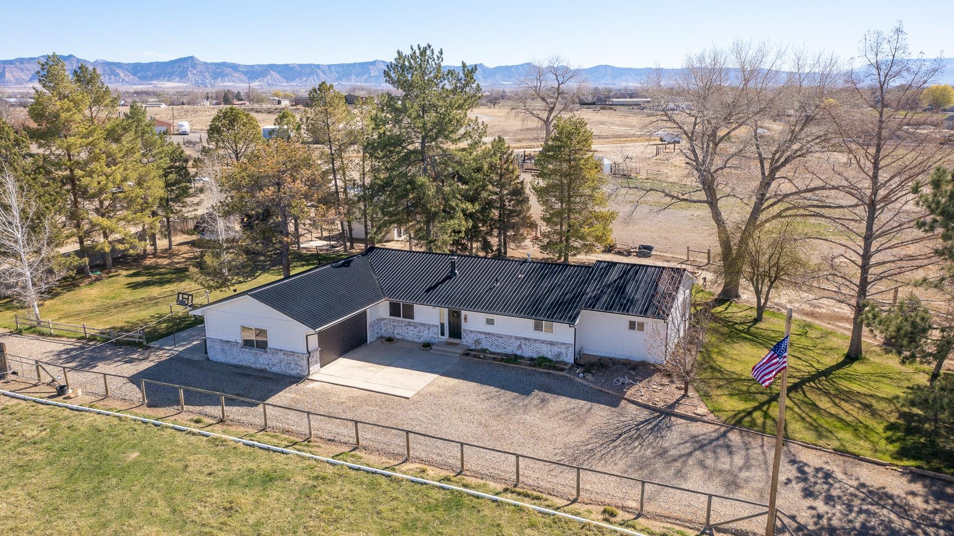 Take a look at this beautifully remodeled home just north of Fruita and conveniently adjoining Monument Ridge Elementary school. The 4-bedroom, 3-bath home features 2 primary bedrooms, a beautiful country kitchen, and an office or formal dining room space. Outside, enjoy the views from the gorgeous yard which features a concrete patio with a hook-up for your hot tub. The home is surrounded by irrigated pastures which have their own head gate. If you have animals, bring them all. It is 4-H ready! The outbuildings contain lamb/pig pens and a cool barn/shop for the cattle or horses. All of which have automatic waterers installed and ready-to-go. Looking for a development opportunity? The property's location within the Fruita Urban Development Boundary, proximity to Monument Ridge Elementary, Oak Creek Subdivision, and Fruita Mews offer countless possibilities.  You have got to check this one out!