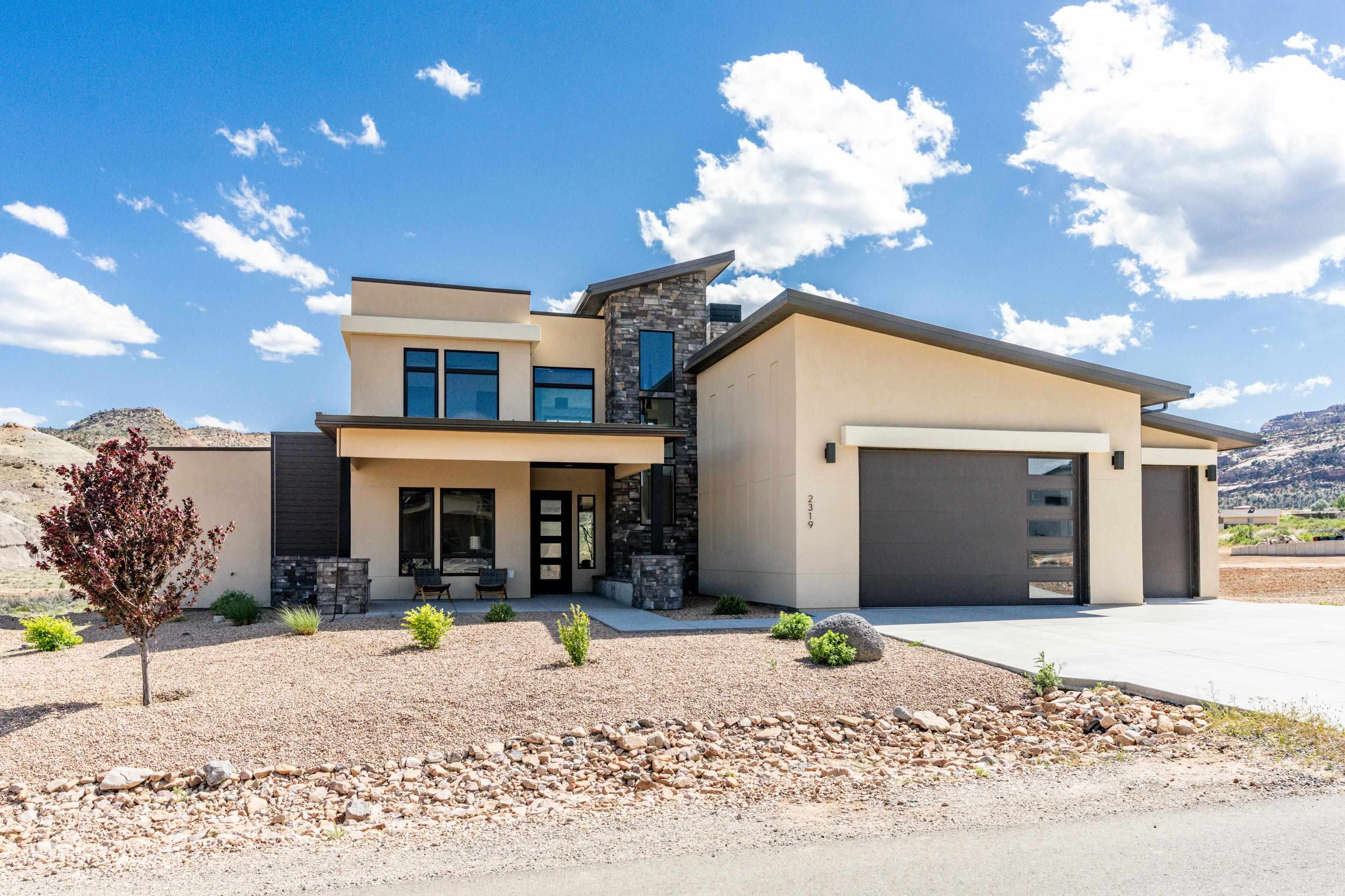 Welcome to your recreation paradise in Western Colorado! Nestled at the trailhead of exhilarating mountain bike trails, this sophisticated contemporary masterpiece awaits you. Boasting 4 bedrooms and 3 bathrooms, this home is a harmonious blend of luxury and adventure.  As you step inside, you're greeted by sleek, modern architecture that perfectly complements the surrounding natural beauty. Floor-to-ceiling windows frame breathtaking views of the Colorado National Monument, inviting the outdoors in and bathing the interiors in natural light.  The heart of this home is its spacious living areas, thoughtfully designed for both relaxation and entertainment. The open-concept layout seamlessly connects the living room, dining area, and gourmet kitchen, creating an inviting space for gatherings.  Retreat to the luxurious master suite, where tranquility awaits. Wake up to panoramic views of the Colorado landscape, then pamper yourself in the spa-like ensuite bath, complete with a soaking tub, dual vanities, and a walk-in shower.  Guests will feel right at home in the additional bedrooms, each offering comfort, privacy, and scenic views. A well-appointed guest bathroom ensures convenience and style for all.  For outdoor enthusiasts, this property is a dream come true. Situated on 1.37 acres, the expansive grounds offer ample space for recreation and relaxation. Whether you're soaking in the sun on the patio or stargazing under the vast Colorado sky, every moment here is a cherished experience.  Adventure awaits just beyond your doorstep, with direct adjacent access to mountain bike trails that promise endless thrills and excitement. And for those with a passion for exploration, the East Entrance of Colorado National Monument is less than a mile away, offering hiking, wildlife viewing, and unparalleled natural beauty. 3 car garage to store all of your toys including an 11' tall 3rd bay for your recreation van!   For those seeking a home for their outdoor lifestyle, this property is truly one-of-a-kind. With its contemporary elegance, breathtaking views, and unbeatable location, it's more than just a home—it's a gateway to endless adventures in Western Colorado.