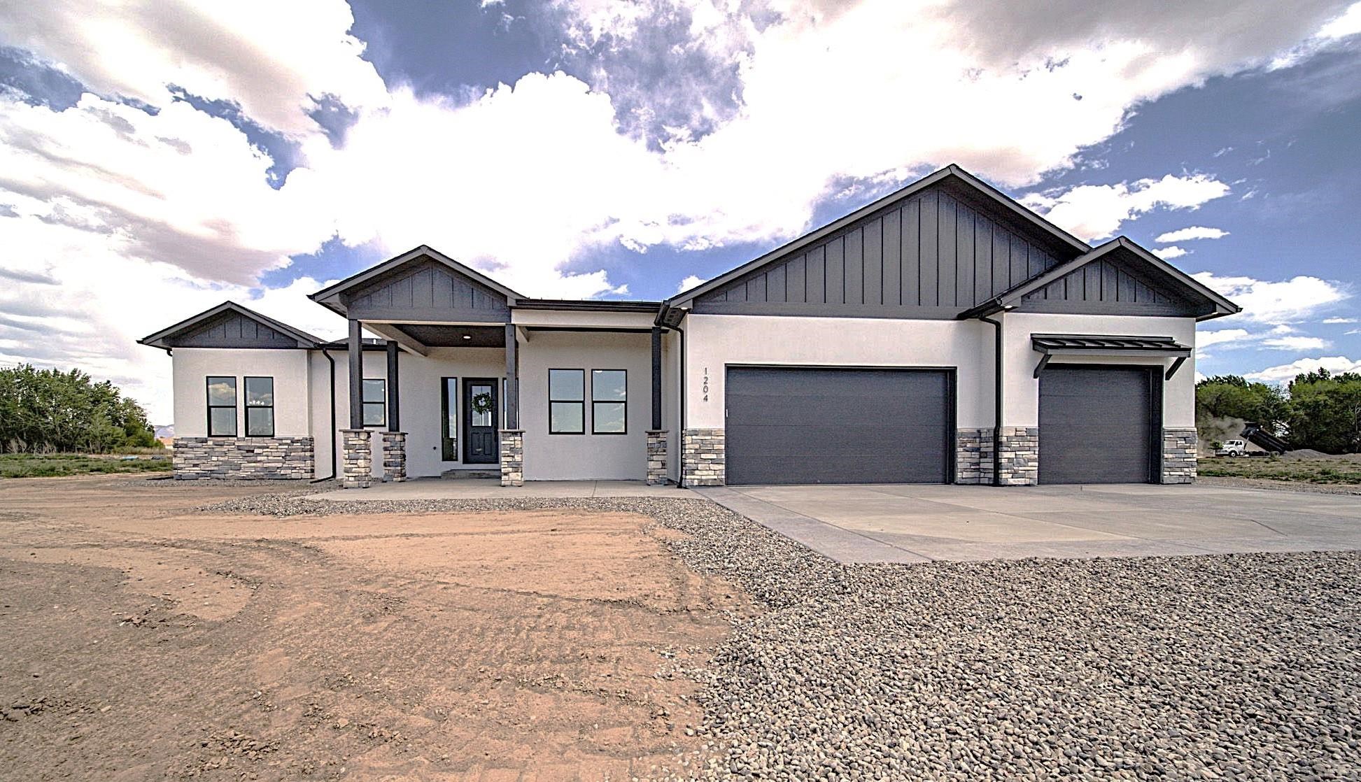 Ranch style, NEW construction home with front landscaping now being installed on a one-acre lot just outside of downtown Fruita. The split floor plan, 4-bedroom home offers tall ceilings and an open concept layout perfect for entertaining. The stunning quartz island is the centerpiece of a chef’s kitchen, complete with KitchenAid appliances, including a refrigerator and beverage cooler in the built-in coffee bar. Natural light floods the space through stylish black windows in the dining room and the primary suite alike. A covered patio is oriented for enjoying the privacy of a spacious backyard ready for personalization. Come see why this home has so much to offer: tankless water heater, gas range, finished garage, pedestal soaking tub, mud room, laundry sink, and more.