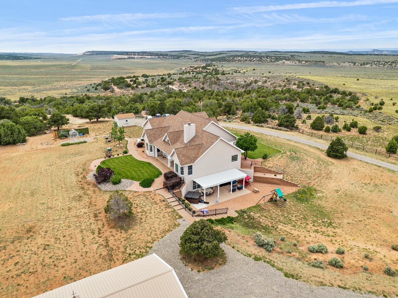 Experience the pinnacle of peace & privacy in this stunning home situated on a 60-acre property in Glade Park, Colorado. Surrounded by over 1000 acres of BLM land, this property offers uninterrupted, breathtaking views of the Colorado National Monument’s landscape. As you enter the front door, you are greeted by an open & modern entryway, accented by elegant column pillars & arched doorways. The adjacent living space is bathed in natural light, & offers panoramic views through large windows. The spacious dining area, with its updated fixtures, is the perfect spot for entertaining. The kitchen is a chef’s dream, featuring beautiful wooden cabinetry, granite countertops, stainless steel appliances, & a sit-up counter for casual dining. An additional eating space, with bay windows, provides a serene & unmatched dining experience. The large primary living area has vaulted ceilings, a stone fireplace with a mantle, & built-in shelving, creating a luxurious atmosphere. Adjacent to the living area, the expansive primary suite offers beautiful fixtures, bay windows, & easy access to the backyard. The five-piece en-suite bath is the perfect place for pampering & relaxation, with dual vanities, a large walk-in shower, & a soaking tub, complemented by two large walk-in closets for all your wardrobe needs. Across the home, an additional guest suite offers great views & access to an en-suite full bath. The conveniently located laundry room on the main floor includes ample cabinet space & a sink for ease of use & convenience. Descend to the large, fully finished basement, which offers a wet bar for all your entertaining needs, a home gym, two spacious bedrooms with ample closet space, & both a full & a half bath for added convenience. The basement also includes a utility room for storage. The oversized three-car garage provides ample space for all your toys, projects, or hobbies. Step out & enjoy the scenery from the large covered pergola patio, perfect for soaking in the sun & dining al fresco, or relax in the hot tub & let your cares melt away. The property features a large outbuilding for additional parking or use as a workshop/hobbyist space. Just to the side of the 24x48 heated out building is RV parking, great for the outdoor adventurer. A greenhouse & garden area complete the outdoor space, providing what you need to cultivate your green thumb. Gated partial fencing throughout & additional potential to finish the upstairs sqft. This home will leave you in awe!