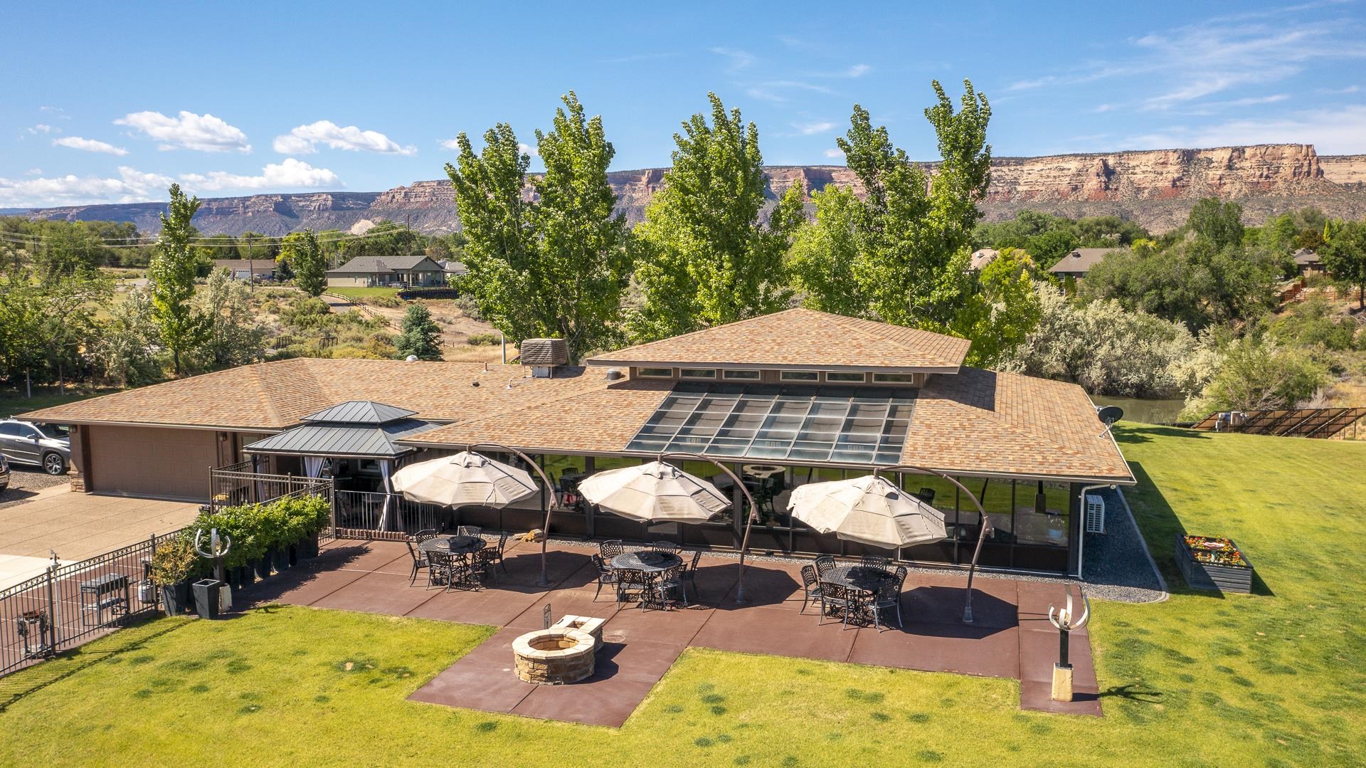 Enjoy your favorite beverage on the spacious patio while watching the sunrise and sunset. This southwestern-style home boasts 5,001 sq. ft. that rests on 5.53 acres of breathtaking, panoramic views of the Colorado River, Bookcliffs, Mesa & The Colorado National Monument! The kitchen has newer appliances including double ovens, gas range, granite counter-tops, and a large walk-in pantry. Offering 3 bedrooms, 3 bathrooms, separate office, and a beautiful living room that extends to the heated & cooled sunroom. Radiant floor heating provides ample warmth, plus a beautiful gas fireplace surrounded by built-in bookcases. The spacious finished basement is great for entertaining with custom-built wet bar, refrigerator & wine cooler. 46X 32’ detached shop/garage with an upper-level office and room for 2+ more cars. If you would rather be outdoors, you can go fishing in your very own private pond! This beautiful home is the perfect place to create those priceless memories for generations to come! Solar is owned! NO HOA! Don't miss the Video Tour!