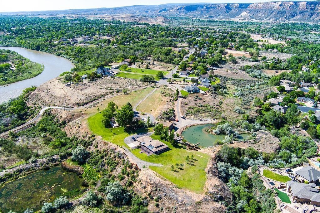 If you are looking for VIEWS & PRIVACY, look no further!   It boasts 5,001 sq. ft. (3,141' on the main level & 1,860' lower level/flex room) that sits on 5.53 acres of breathtaking, panoramic views of the Colorado River, Bookcliffs, Mesa & The Colorado National Monument! Pride of Ownership shows inside & out. The kitchen has newer appliances including double ovens, gas range, granite counter-tops, and a large walk-in pantry. Offering 3 bedrooms, 3 bathrooms, separate office, and a beautiful living room that extends to the heated & cooled sunroom. Radiant floor heating provides ample warmth, plus a beautiful gas fireplace surrounded by built-in bookcases. The spacious finished basement is great for entertaining with custom-built wet bar, refrigerator & wine cooler. 46X 32’ detached shop/garage with an upper-level office and room for 2+ more cars. If you would rather be outdoors, you can go fishing in your very own private pond! This beautiful home is the perfect place to create those priceless memories for generations to come! Solar is owned! NO HOA! Don't miss the Video Tour!