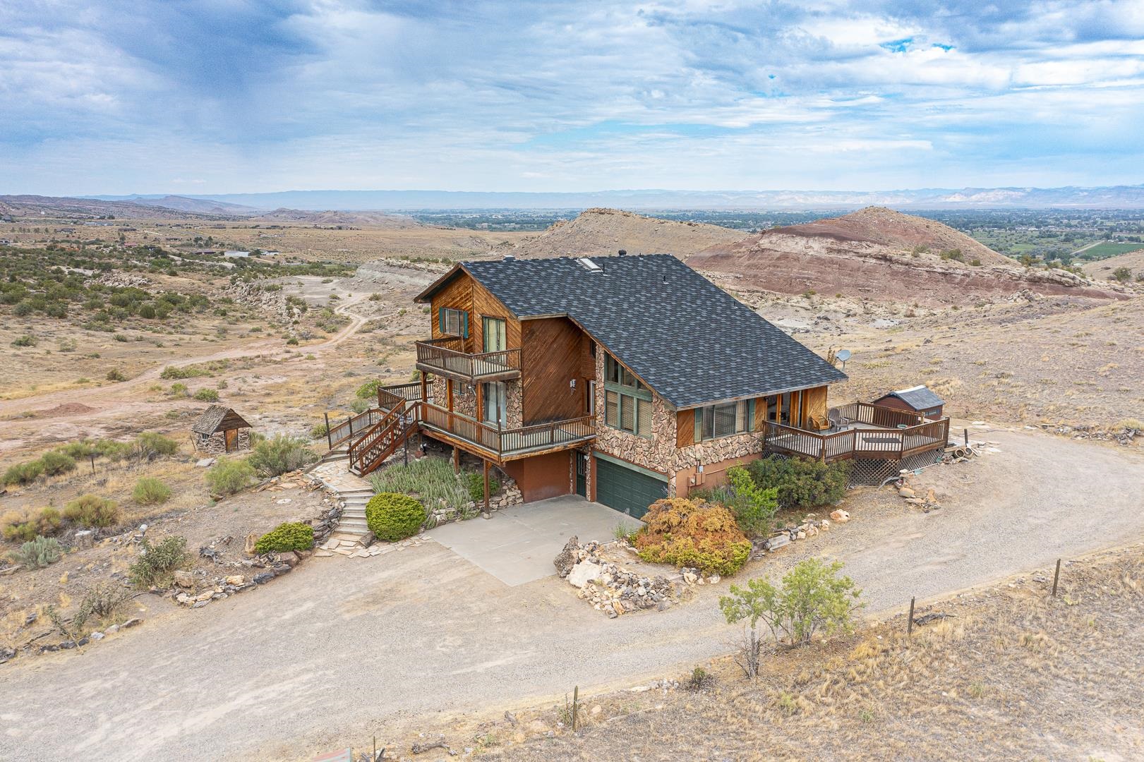 360 degree views and right at the entrance to the Monument Canyon Trail.   This 2-story with walkout basement has amazing views and has a lot of potential.  Needs some TLC, but easy to do.  Nothing structural, except the decks that wrap around 3 sides need some attention.  Extra large master bedroom needs carpet and bath needs a vanity.  There are 2 refrigerated coolers and 2 furnaces.  Hot water tank is approx 6 months old and washer is new.  Septic pumped in last 4 months.  Real Oak floors in kitchen and living room.  Electric 6 burner cook top, JennAire built-in microwave oven, with breakfast bar and formal dinning room.  Huge vaulted ceilings in living room with tons of light and views.  Family room downstairs has tongue and groove ceilings with built-in cabinets, counters and sink, and a Murphy bed - could be an in-law set up.  Also off the 2 car garage is a 13 x 21 separate shop.  Newer shed in back stays.  This home could be your lucky find.