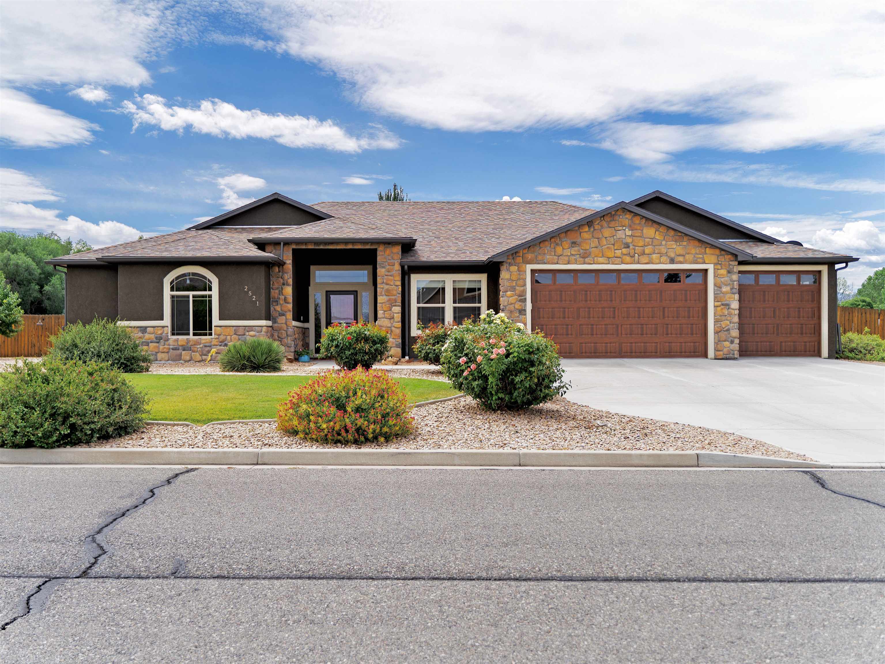 Welcome to your dream home in the picturesque Greystone Estates! This charming 2,195 sq. ft. ranch-style residence sits on over an acre of land, offering the perfect blend of luxury and functionality. With 4 spacious bedrooms and 2 well-appointed bathrooms, this home is designed for both comfort and convenience. The open, flowing main floor plan is ideal for entertaining, featuring a cozy gas fireplace that adds warmth to the living area. The large kitchen is a chef’s delight, boasting stainless steel appliances, granite countertops, and a generous dining space perfect for gatherings. The master suite is a serene retreat, complete with a 5-piece bath featuring a garden tub, a custom-tiled walk-in shower, and a spacious walk-in closet. Enjoy seamless indoor-outdoor living with direct access to the covered patio from both the main living area and the master suite; featuring gorgeous views of the Colorado National Monument from the back porch and the Book Cliffs from the front porch. The oversized 3-car garage offers ample storage space for your vehicles and toys. The property is  landscaped with irrigation systems in both the front and back yards, with a fully fenced backyard. Currently, the back third of the lot serves as storage for a RV,  but holds potential for more. Zoned to allow for some agricultural use with plenty of room in the back area for a barn and/or small pasture. Embrace the serene lifestyle of Greystone Estates while enjoying the versatility and beauty of this exceptional home!