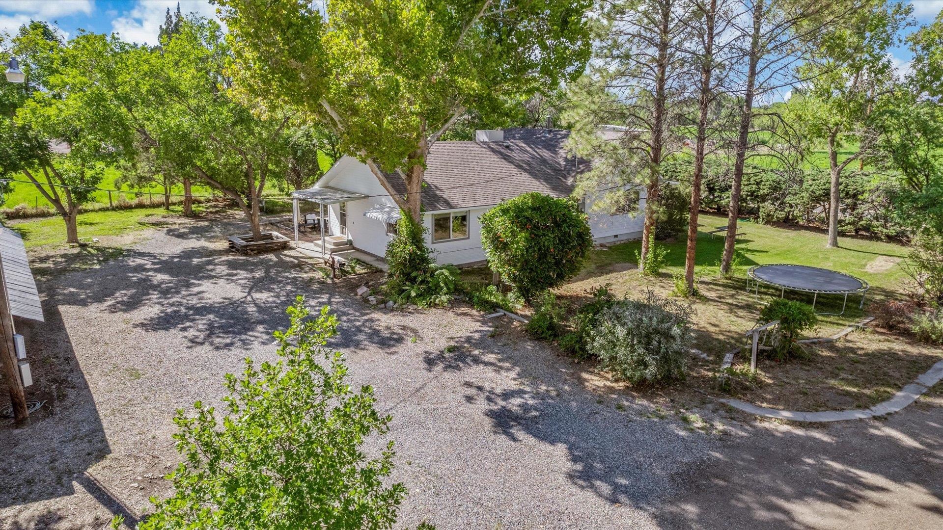 This amazing, recently remodeled and updated 1,652 sq ft home sits on over 5 acres, and boasts a very private, rural setting while being just minutes away from downtown Grand Junction. These hidden gems do not come around very often.  The owners of this beautiful property had a vision and brought it to life. Pride of ownership is an understatement. The work has already been knocked out! New roof, new electrical, new flooring, new paint, new cabinets, new plumbing all the way to the street, 220 already ran for the RV plus several other upgrades.  Not to mention the limitless possibilities with the existing workshop, already wired with 220, additional outbuildings, chicken coop, and even 2 authentic, vintage train cars. This property is zoned as agricultural with ample water allocations from Palisade Irrigation District that transfer with the purchase of this amazing property. You are limited only by your own imagination. Minutes away from Palisade, enjoy all that the town of Palisade has to offer. Located in the Palisade Buffer area and the Palisade HS school zone, this is a great location for the entire family. Could this be your forever home?