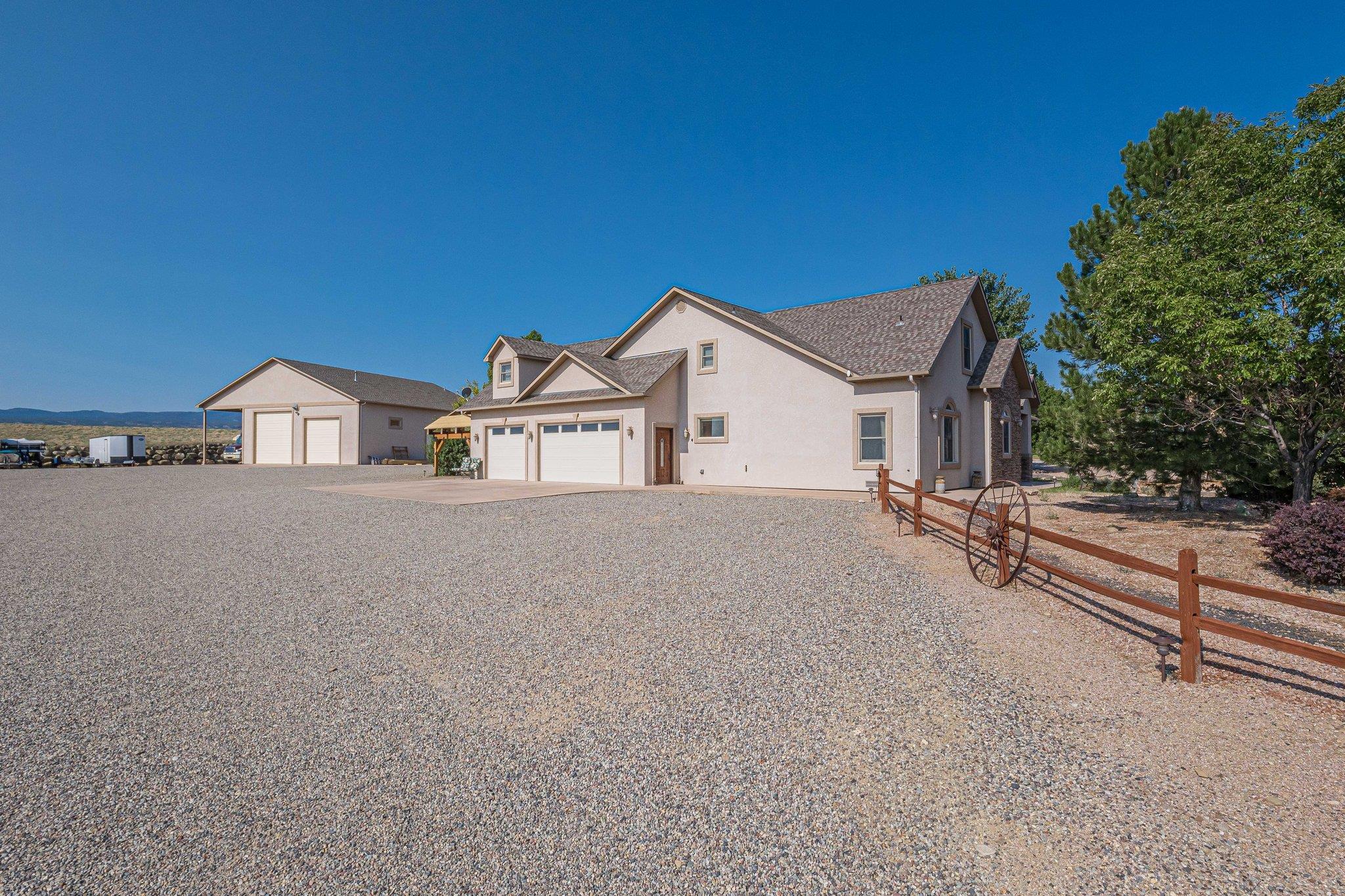 Discover the perfect blend of luxury and functionality in this stunning 4-bedroom, 4-bathroom home with 3,573 square feet of living area. This home boasts vaulted ceilings that enhance the sense of space and openness and provides ample room for family living and entertainment. The chef’s kitchen features knotty alder cabinets, sleek granite countertops, and stainless-steel appliances, creating a perfect space for cooking and gathering. Enjoy year-round comfort with refrigerated central air and cozy up by the gas log fireplace during cooler months. Situated on 2.58 acres, this property also offers solar power, a 3-Car Garage, covered RV parking with hookups, heated/cooled 40x60 shop with 220 outlets, storage loft, and in-floor heat in the shop office and bathroom. Nestled just outside the city limits, this property offers breathtaking views and an inviting atmosphere that combines comfort with elegance. Don’t miss this exceptional opportunity to own a home that perfectly balances quality craftsmanship, modern conveniences, and serene surroundings. Schedule your personal viewing today!