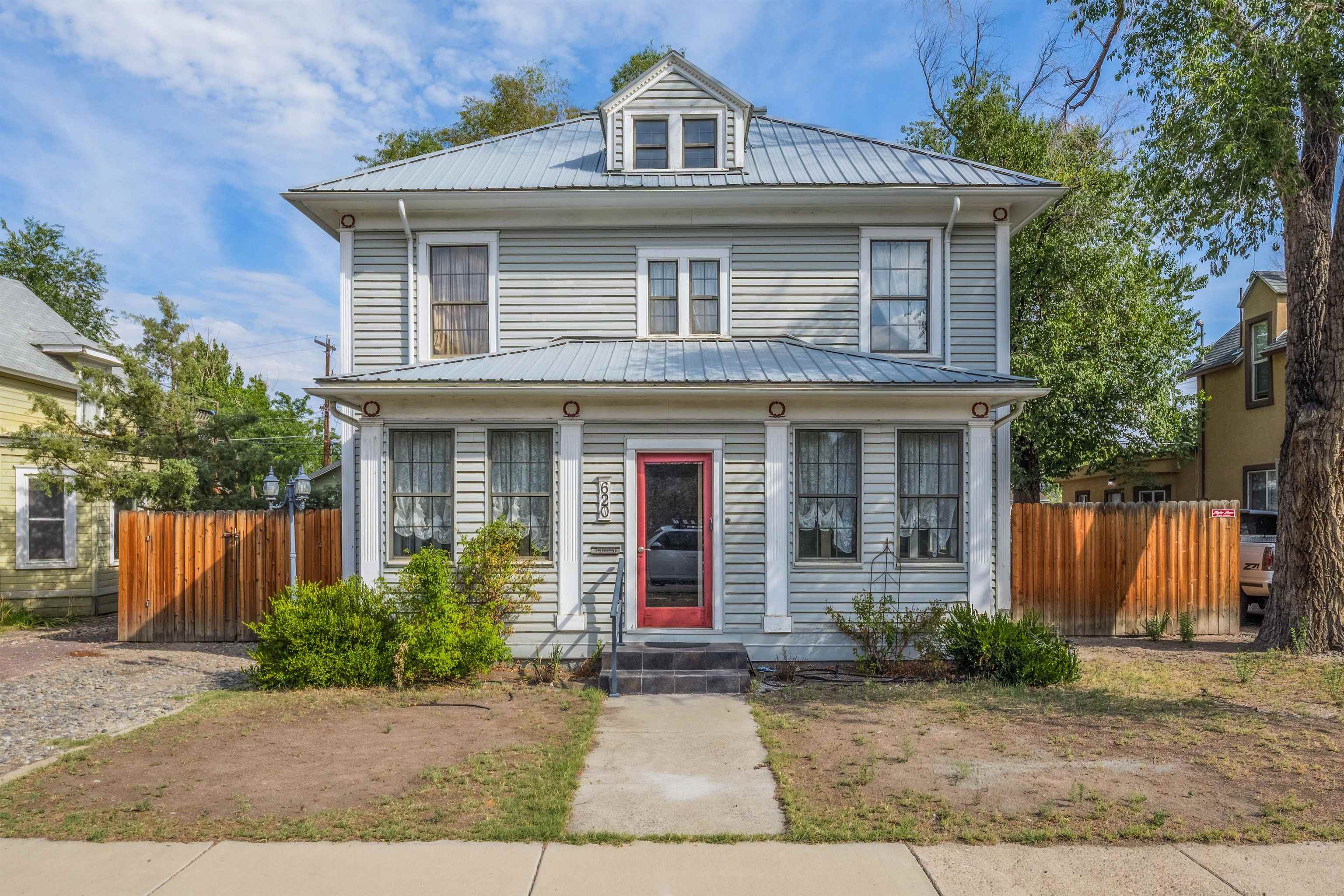 This is a charming turn-of-the century two story home in the heart of vibrant downtown Grand Junction!  The entrance greets you with a completely enclosed porch.  Step into the home and go back in time!  The preserved original woodwork is beautiful along with the period wallpaper and ornamental accents.  The wood floors can be restored to their former glory. The main level consists of 2 living spaces, 1 formal and 1 informal.  A quaint office space or craft room. An open kitchen and dining area with a large pantry.  Also, an additional living space with its own entrance, kitchenette and full bath.  Upstairs boasts 4 bedrooms (2 are non-conforming due to no closets), one 3/4 bath and one 1/2 bath, Also, an expansive bonus or flex room with its own exit to a staircase descending to the backyard.  The backyard has two storage sheds and a nice retreat area with ally access. There is a newer furnace and a tankless continuous hot water heater.  It was re-roofed in 2012. Some electrical upgrades have been done. Make your showing appointment today!