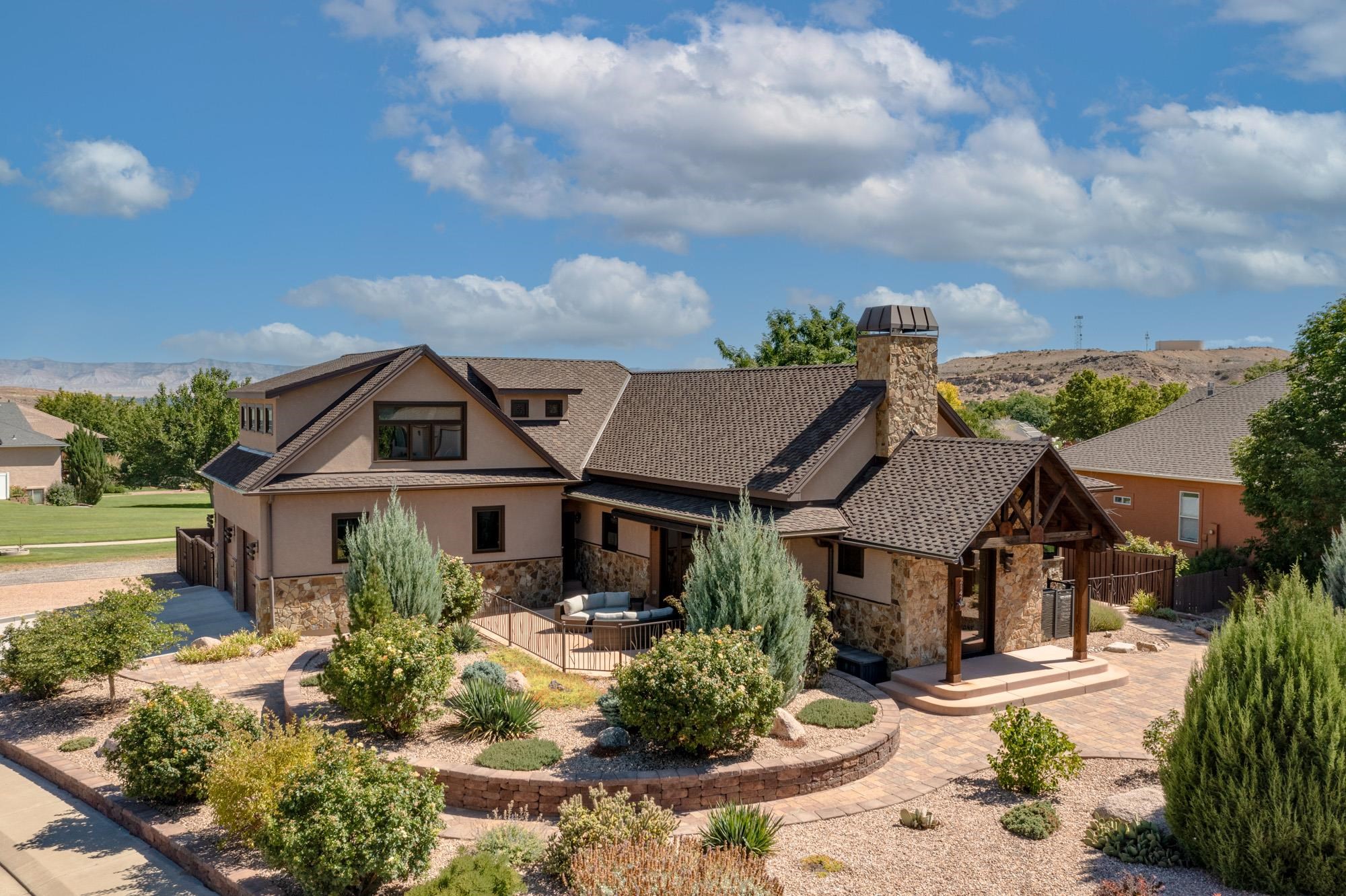 Mountain contemporary four bedroom home with oodles of unique custom features. Close views of Granite Falls and Liberty Cap on the CO National Monument in a neighborhood setting with plenty of sidewalk paths and walking distance to the Elementary School. Entertain in the great room that opens to a patio through a wall of bi-fold doors with retractable screen and an automatic awning for cover. Enjoy a gourmet kitchen with commercial grade appliances, custom cabinetry, unique sandalwood stone entertainment island and wet bar. View the Book Cliffs from the primary bedroom and don't miss the semi-precious stone featured in the bath. Humidifall water feature provides healthy humidity to the main living area. Savant System with integrated audio, video, security and environmental sensors throughout the home – all managed via a phone/tablet app. Custom iron work (interior/exterior) by local and Boston artists. RV carport with 50A service and dump. 30A service in attached garage for charging an electric vehicle. Additional finished spaces include a loft, a rec room gym, a wine closet and a multipurpose room. Professionally landscaped and fully irrigated as part of HOA. Another bedroom and bath are roughed-in for a future in-law/au pair suite.