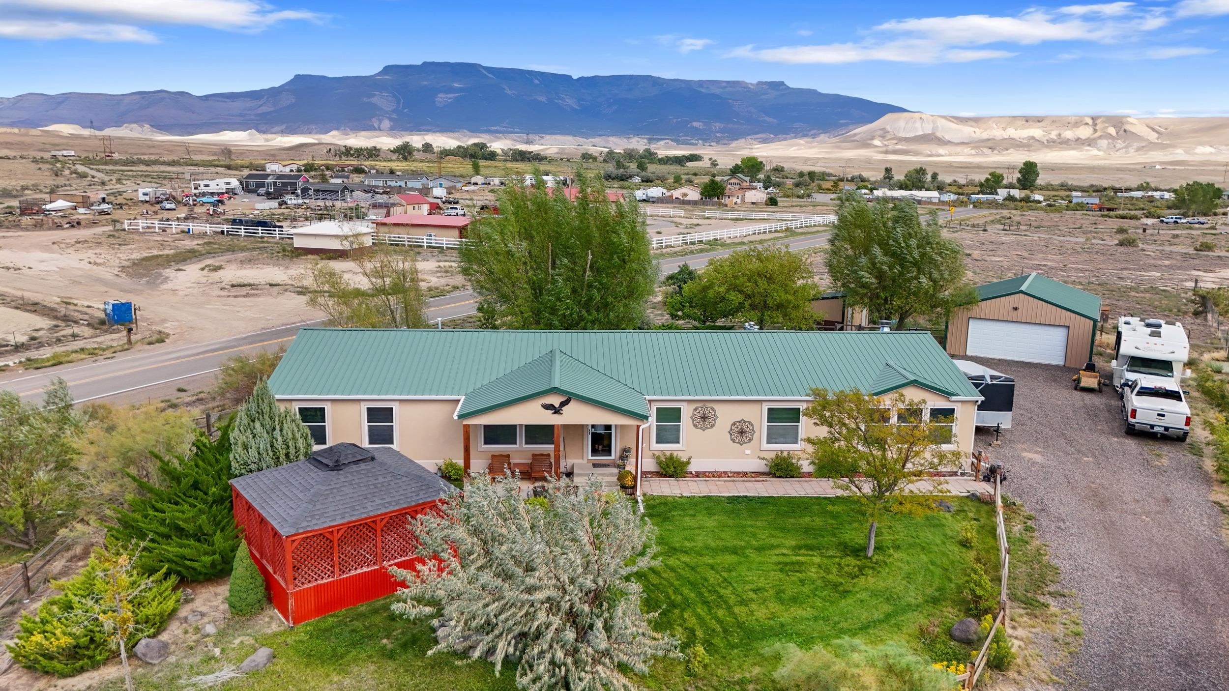 Nestled on a serene 2-acre lot in Whitewater, Colorado, this beautifully appointed 1 owner home has 4 bedrooms, 2 baths and offers the perfect blend of comfort, space, and functionality. It also has 2 very large living spaces and a huge walk in pantry!! Envision mornings where you step outside to take in breathtaking views of the Grand Mesa, surrounded by lush, mature landscaping and nourished by plentiful irrigation water. Whether you’re an outdoor enthusiast with a passion for RVs, toys, or livestock, or simply someone who craves privacy and open space, this property is the ideal sanctuary. The residence is complemented by an impressive 40’ x 60’ shop, featuring 14-foot and 10-foot doors—perfect for storing large vehicles, equipment, or for use as a workshop. In addition, the detached 23’ x 28’ garage offers even more storage and utility. For moments of relaxation, unwind in the comfort of the enclosed, screened-in hot tub room, or enjoy the expansive patio with its integrated fire pit—ideal for evening gatherings under the stars. This property also offers a thoughtfully designed space for hobby farming, complete with a chicken coop, making it a great fit for those with agricultural interests or simply seeking a bit of rural charm. With ample room to roam and customize, this home is more than just a residence; it’s a lifestyle for those seeking the tranquility of country living with all the amenities you could need. Seize the opportunity to own this unique piece of paradise—whether you’re looking to raise animals, store recreational vehicles, or simply savor the quiet beauty of your surroundings, this home in Whitewater offers it all.