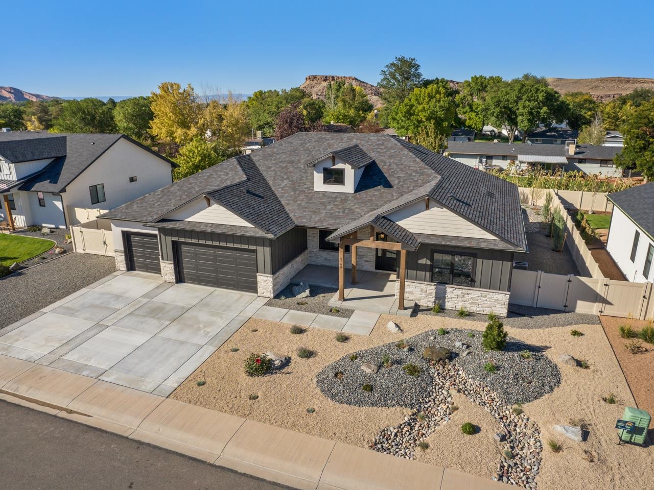 A newly built, elegant home with a timeless and craftsman in-style feel is awaiting you to make it yours. Located in the Granite Falls subdivision in the Redlands you’ll love what the area provides, especially the views of the Monument right out your door. As you approach the home you’ll immediately begin to take note of all its uniqueness. The front yard of the property is immaculate with easy maintenance xeriscaping. The front of the home has a sleek look with its black board and batten siding that is complemented by the stone. The interior is just as beautiful, as you’ll step into a very open, stylish and clean living space. Admire the ceiling beams that were built on site with white oak, or the cultured stone fireplace with inset custom cabinets. The kitchen has spectacular quartz countertops, floor to ceiling cabinets, a kitchen island to match, Z-line appliances and a custom made range hood. There is lots of room in the butler’s pantry with butcher block countertops and a wine and beverage fridge. The whole home utilizes high end fixtures with energy efficient bulbs. The front office comes complete with gold accents, black cabinets, accent wall, quartz counters and matching window sills. The primary suite is quite large, and has access to an amazing five piece bathroom. There is a spa-like feel as you’ll marvel at the golden moen temperature-controlled faucets and fixtures, the large free standing tub and the walk-in shower with floor to ceiling tile, and custom niches for products. Not to mention the enormous walk-in closet with lots of wardrobe space and storage. The additional three large bedrooms contain custom closets and have easy access to the additional bathrooms all of which include gorgeous fixtures and tile work. The laundry room is massive and finished with a custom bench seat, black granite countertops with a unique feel, and wall hooks that help make it an excellent mudroom as well. The three car garage is quite large and has easy access to the side yard, ideal for RV parking. The backyard has a wonderful covered patio to enjoy in any weather and the lovely views. And the backyard is well landscaped and easy to take care of. There are so many additional unique features to this home, that you will have to see to believe. Come check it out, and schedule your showing!