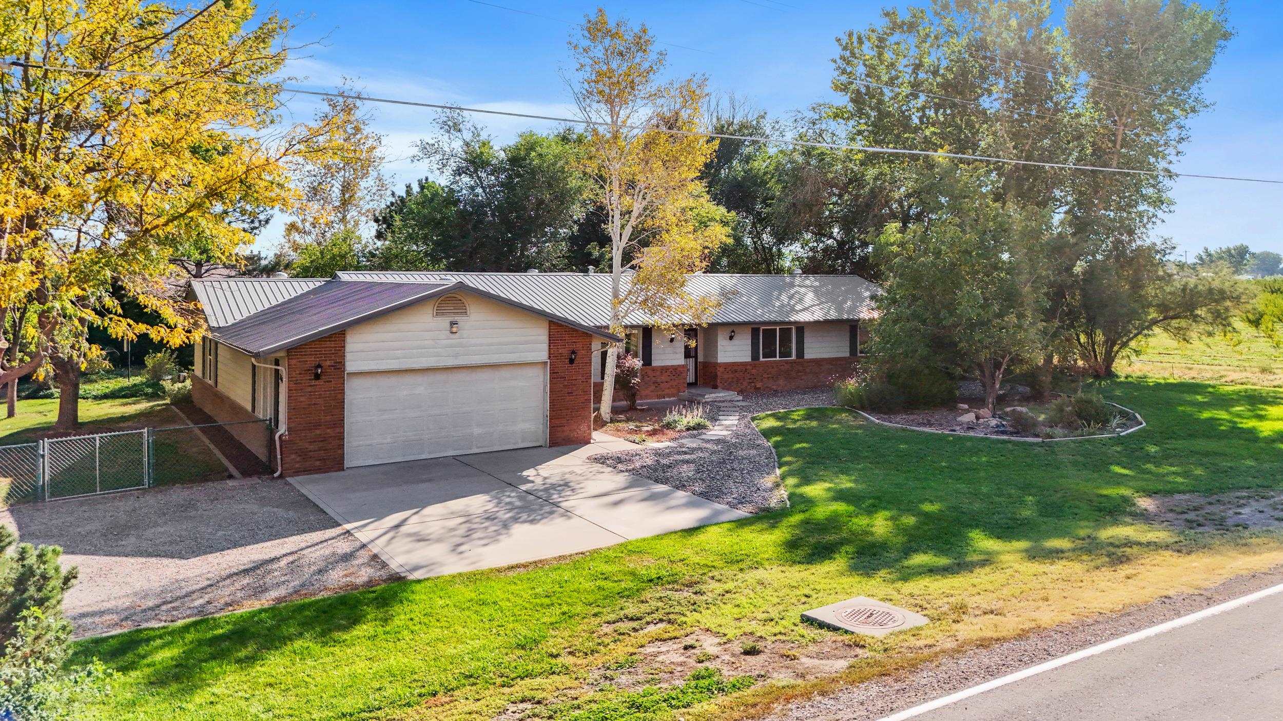 Nestled beneath the majestic Bookcliffs in Palisade, this beautifully maintained ranch-style home offers a serene oasis with stunning landscaping and mature trees. The renovated primary suite features a walk-in closet, luxurious shower, and double vanity. Two additional bedrooms and full bathroom provide ample space. Three inviting living areas complement the well-appointed kitchen, and a separate studio.  This tranquil setting is near all of the Palisade amenities.