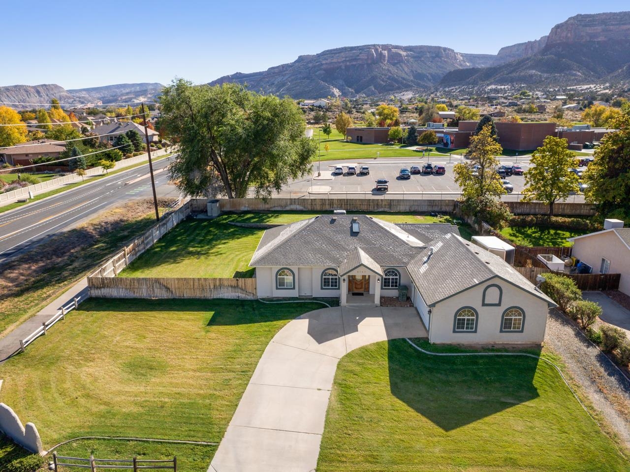 Discover a gem near Colorado National Monument! This Redlands home in Canyon View offers quiet, ideal positioning for outdoor enthusiasts, close to trails and biking paths. Inside, the open-concept design features sleek marble tile and a custom acrylic stairwell wall. Off the entryway, find two office spaces with hardwood floors, stylish fixtures, and large windows. The vaulted living area has skylights, a contemporary fan, surround sound, and a gas fireplace. The chef’s kitchen boasts stainless steel appliances, ample counter space, a kitchen island with a gas cooktop, wall oven, microwave, and a huge pantry. Enjoy morning views in the breakfast nook or host in the formal dining room, which opens to the side patio. The spacious primary suite includes hardwood floors, dual walk-in closets, a cozy fireplace, and a luxurious five-piece en-suite with a jetted tub and walk-in shower. Downstairs, a speakeasy-style wet bar and three more bedrooms make the basement perfect for entertaining. The pergola-covered patio overlooks a vast backyard with Monument views, backed by Wingate Elementary for lasting privacy. This home has it all—come see it for yourself!