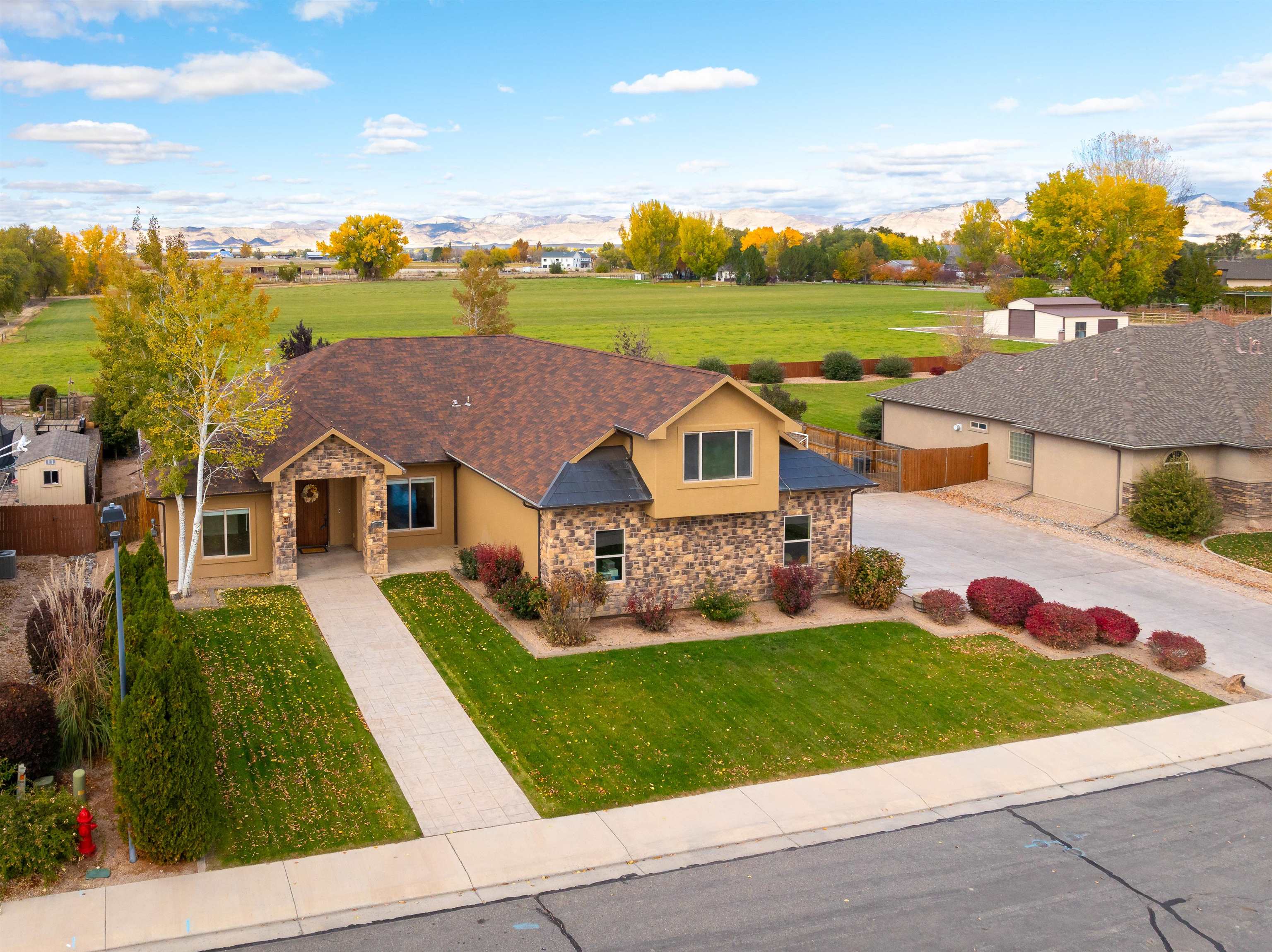 Just shy of 3500 sq. ft., this custom-built home has room for everyone. Featuring 4 bedrooms, office, huge bonus room, 3.5 bathrooms, oversized 3 car garage, gated 29x45 RV parking. This beauty sits on a large lot and backs to farmland with expansive views of the Bookcliffs. The beautifully appointed kitchen is the heart of this home with high-end cabinets, granite counter and copper accents. The primary suite is spacious and relaxing with a large bathroom, soaking tub and walk-in closet. The opposite side of the house features a junior suite with its own entrance and attached bathroom, jack-n-jill style bedrooms with a shared full bathroom.  Upstairs you'll find the bonus room with a wet bar and full-size refrigerator. Top of the line heating & air conditioning with 4 zones. Schedule your showing today!