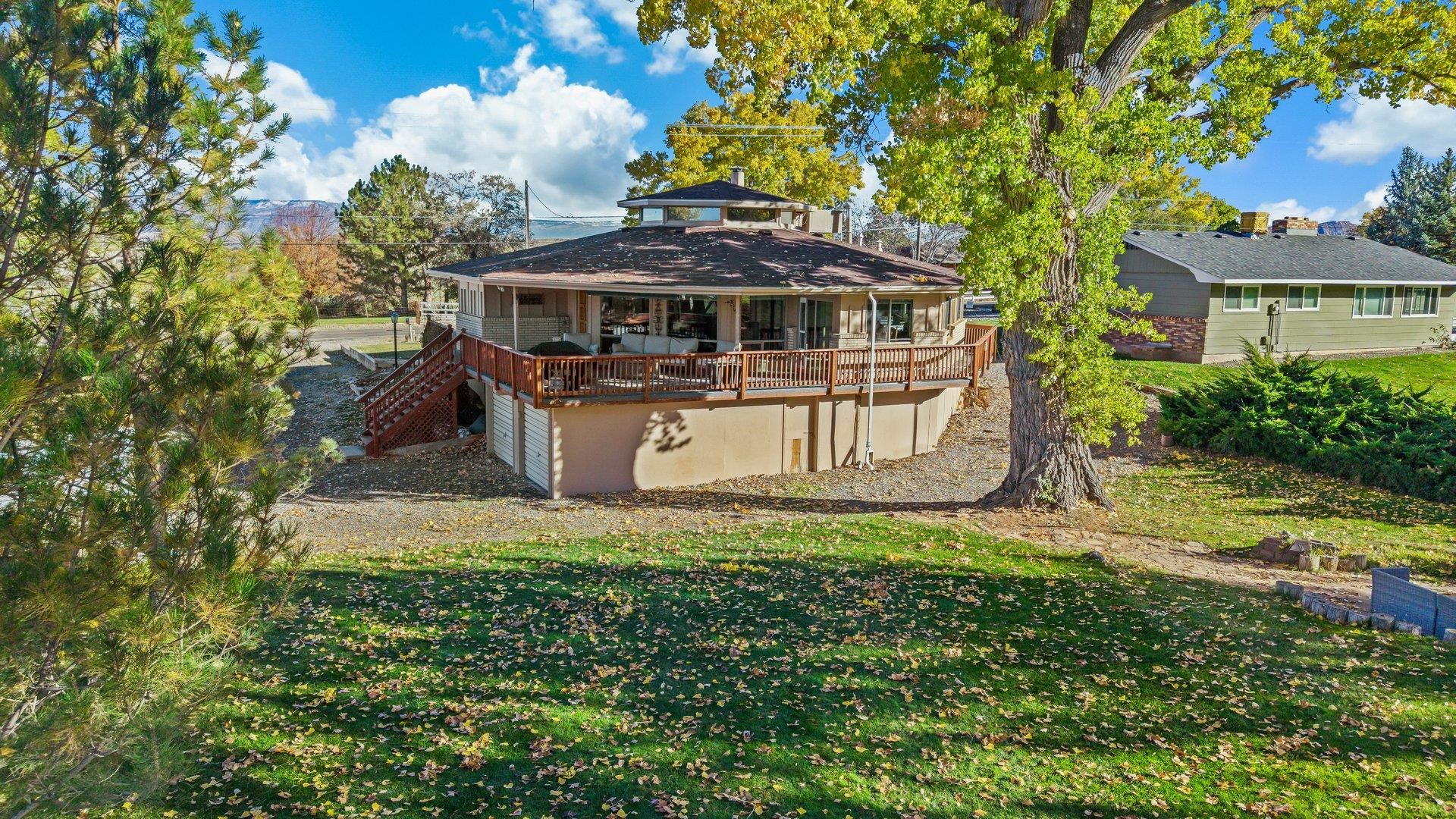 Nestled on the scenic Tiara Rado Golf Course, this unique octagon house seamlessly combines iconic mid-century design with an unbeatable backdrop of breathtaking mountain and golf course views. Enjoy your upper deck with views of the Colorado National Monument as far as the eye can see. In addition, you have a spacious yard with seating area for entertaining, relaxing or roasting marshmallows! The home’s distinctive architecture offers panoramic windows that flood each room with natural light, accentuating sleek lines, warm wood finishes, and authentic mid-century details throughout. Updated bathrooms provide a true spa-like experience. Enjoy spacious, open-concept living areas that invite indoor-outdoor flow, perfect for relaxing or entertaining against a picturesque landscape. Whether you’re an architecture enthusiast or a lover of serene settings, this home is a rare opportunity to experience classic design in a truly unparalleled location. Plenty of space to park your cars in the 2 car garage, plus RV parking for your toys! New roof installed in 2023 with NEW cooler as well as electrical service upgrade in 2022.