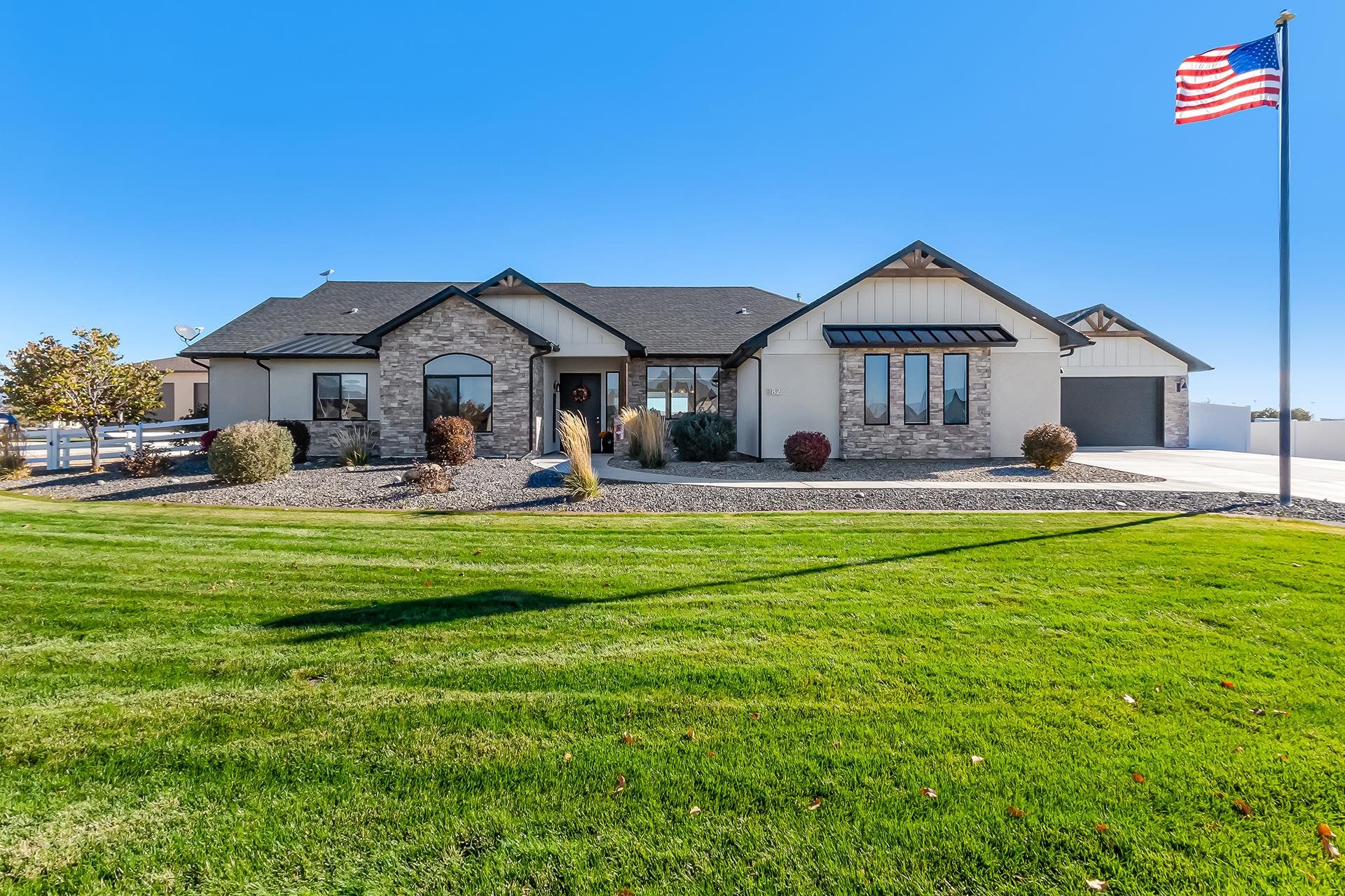 Welcome to this stunning 4-bedroom, 3-bathroom home located in the highly desirable Northwest area of Grand Junction. If you’re seeking privacy and a serene country setting, this property is a must-see! Relax on the covered back porch and take in the breathtaking, unobstructed views of the Book Cliffs and Grand Mesa, or enjoy the Colorado National Monument views from the front of the home. Set on a beautifully landscaped 1.06-acre lot, this home features a full sprinkler system and landscape lighting, ensuring the grounds are as pristine as the interior. Step inside and be greeted by an abundance of natural light flowing through an open floor plan. The gourmet kitchen is a chef’s dream, boasting a gorgeous granite island, soft-close cabinetry, and top-of-the-line GE Monogram appliances, including a six-burner gas range and double ovens. Attention to detail shines throughout, from the tray ceilings with rustic rough-sawn wood beams in the living and dining rooms to the stunning stone gas log fireplace, accented by elegant floating shelves. The spacious master suite offers a luxurious 5-piece en suite bathroom and a walk-in closet. With parking for four vehicles in the attached garages and a massive RV parking area on the south side of the home, there’s no shortage of space for all your needs. The South driveway leads to an impressive 65' x 30' workshop with oversized garage doors, offering 1,950 sq. ft. of endless possibilities. Outfitted with a 60-amp single-phase panel, LED lighting, and ten GFCI-protective outlets, this workshop is ideal for any hobbyist or entrepreneur. Don’t miss your opportunity to see this incredible property. Schedule your private showing today!