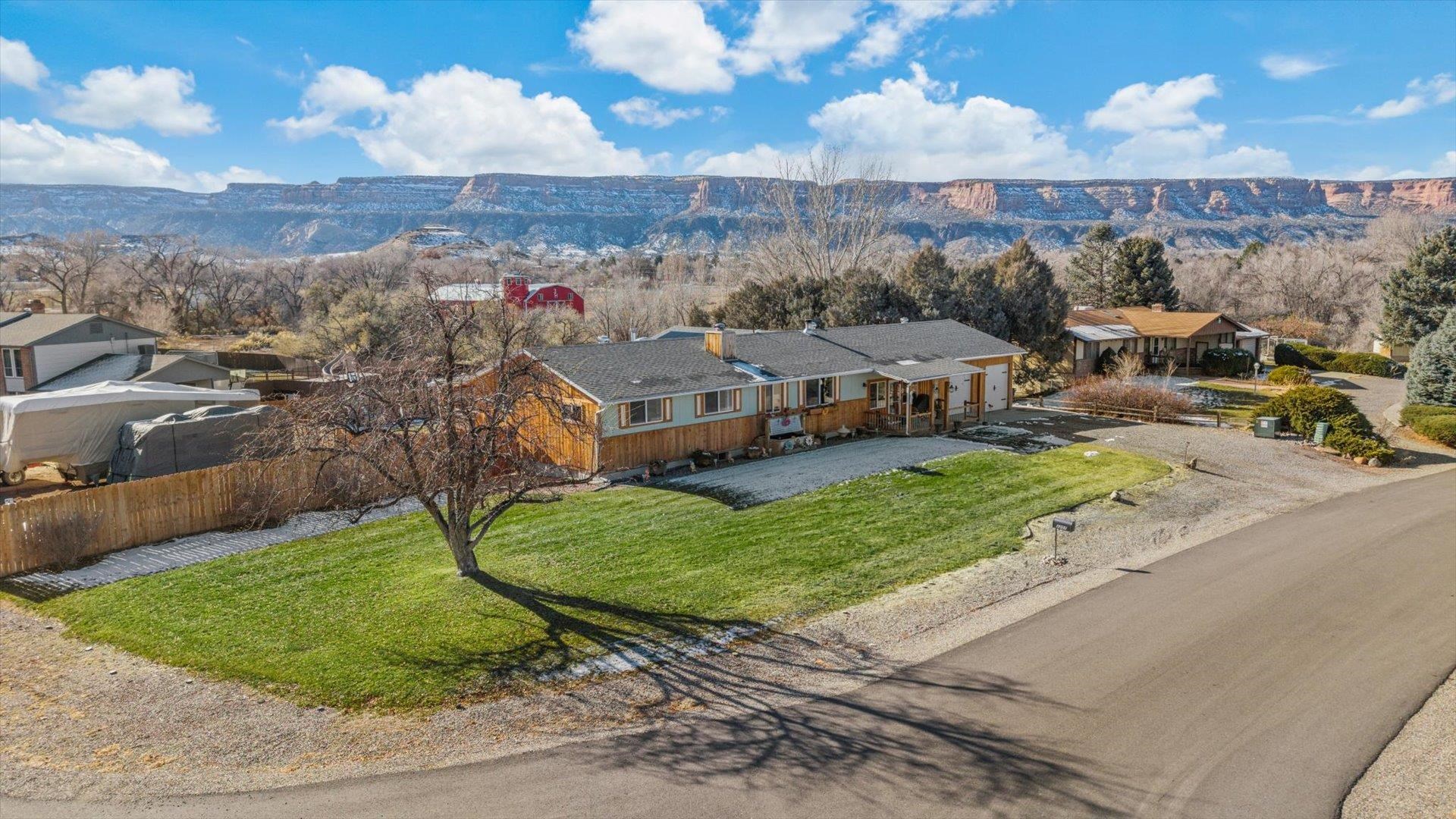 Welcome to your dream retreat in the heart of Redlands, where timeless charm meets the comforts of modern living. Nestled in a serene neighborhood, this thoughtfully updated home beckons you to unwind and savor life’s simple pleasures. The journey begins at the inviting wraparound porch, where every angle offers breathtaking views of the iconic Colorado National Monument. Imagine starting your day here with a steaming cup of coffee, the morning air crisp and fresh, or unwinding at dusk as the horizon is painted in fiery hues of sunset. Step through the front door, and you’re embraced by the warmth of aspen tongue-and-groove walls, creating a cozy yet sophisticated ambiance. Natural light pours through the brand-new windows, illuminating every detail of the interior. The kitchen is a masterpiece of rustic elegance, boasting rich hickory cabinetry and solid wood doors, perfectly complementing the home’s handcrafted character. Every inch of this space tells a story of meticulous attention to detail, from the seamless blend of textures to the thoughtful placement of every element. Outside, a private oasis awaits—a haven designed for relaxation and entertainment. Picture yourself gathered around the custom-built firepit, the crackling flames casting a warm glow, or soaking in the luxurious 8-person hot tub as the starlit sky stretches above. For movie enthusiasts, an outdoor screen transforms your backyard into a cinematic escape, ideal for hosting unforgettable evenings with loved ones. This is where staycations become a way of life, blending the tranquility of nature with the comforts of home. Designed with versatility in mind, the clever floor plan offers two distinct living spaces, opening the door to endless possibilities. Whether you envision welcoming traveling professionals, offering a cozy haven to Airbnb guests, or simply enjoying the extra room for multigenerational living, this property is poised to adapt to your vision. This home is more than just a residence—it’s an experience, a lifestyle, and a sanctuary. Perfectly balancing the artistry of handcrafted design with the serenity of its natural surroundings, it promises a living experience like no other. Don’t miss the chance to call this extraordinary Redlands retreat your own!