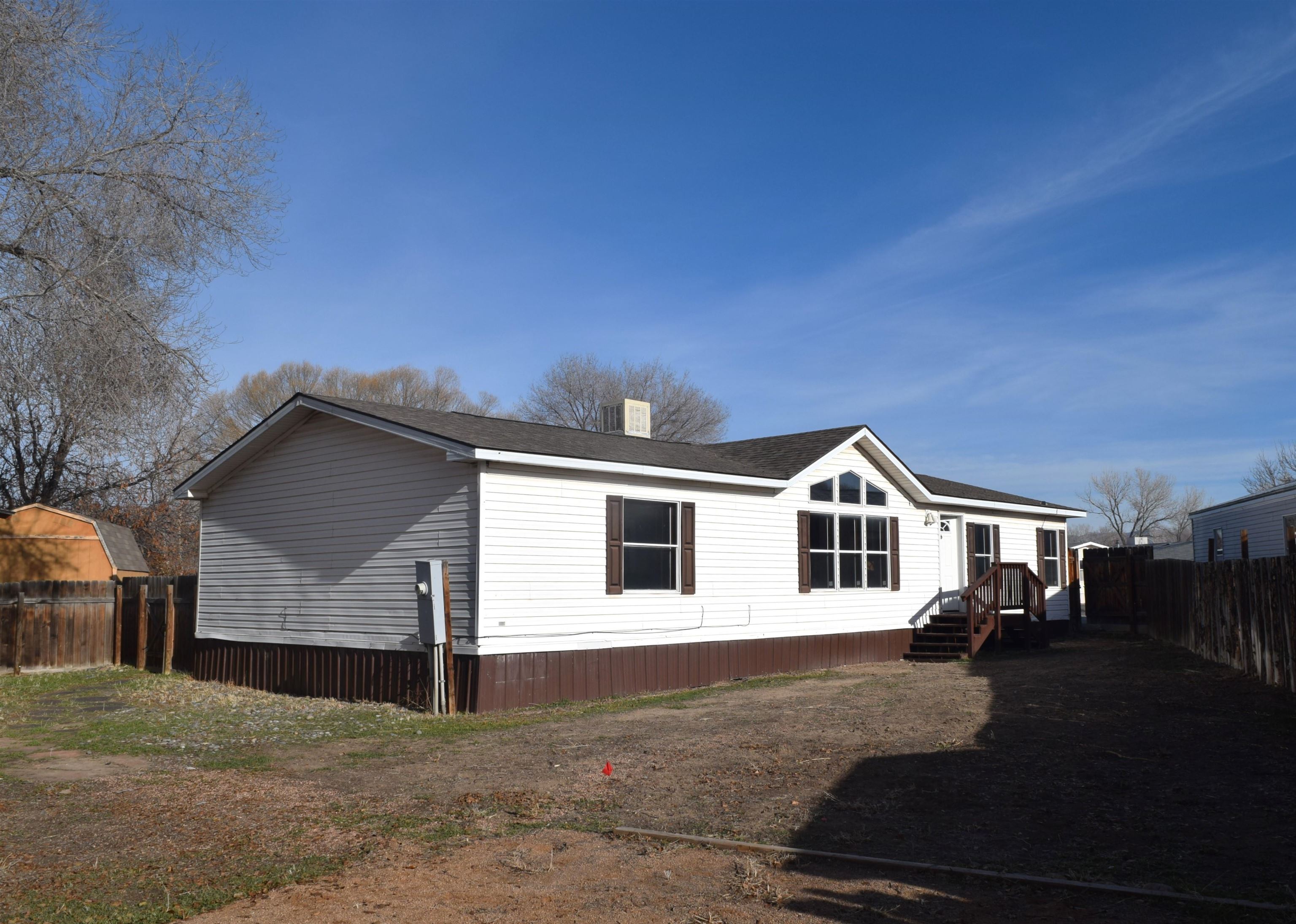 Come check out this nice, roomy home in Fruita's Holly Park. This double-wide manufactured home has 1568 SF of living space on a split-bedroom floorplan. The living and dining areas are open and bright. The main suite has a large, five-piece bathroom with a walk-in closet. There is a private, covered front patio, and a shed in the large, fenced back yard for extra storage. The paved driveway is nice and wide with plenty of parking. Irrigation water is available through the HOA. The home is located on a small, quiet cul-de-sac, yet close to Fruita-area schools and shopping. Schedule your private viewing today.