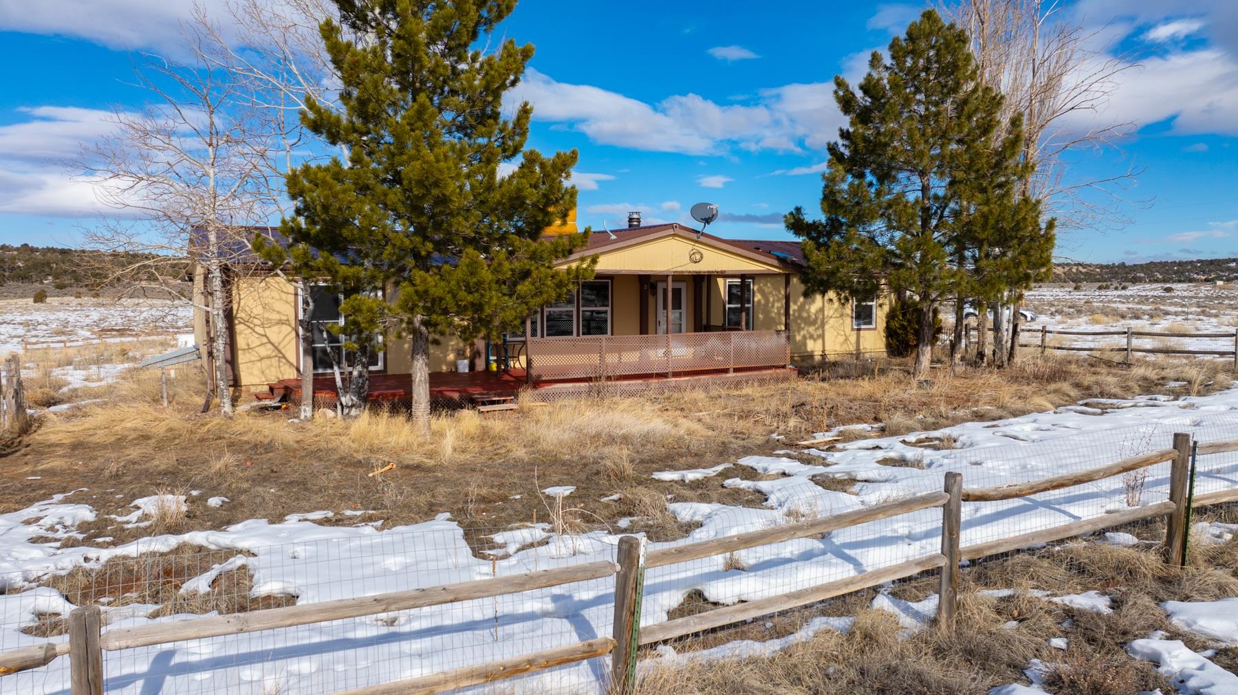 40 acres with a nice sized home and 1800 square foot heated/cooled outbuilding! The home offers a wood burning fireplace and a southeast facing covered patio to enjoy the views. The large kitchen has newer cabinets with granite countertops and the large living room brings rays of afternoon sun. The primary bedroom has a sliding glass door to the back deck and 3 more conforming bedrooms, plus an office. The outbuilding can be modified for vehicles or toys and has an A/C window unit, evaporative cooler unit and wood burning stove!! Don't forget the 360 degrees of amazing views and trees. HOA is optional.