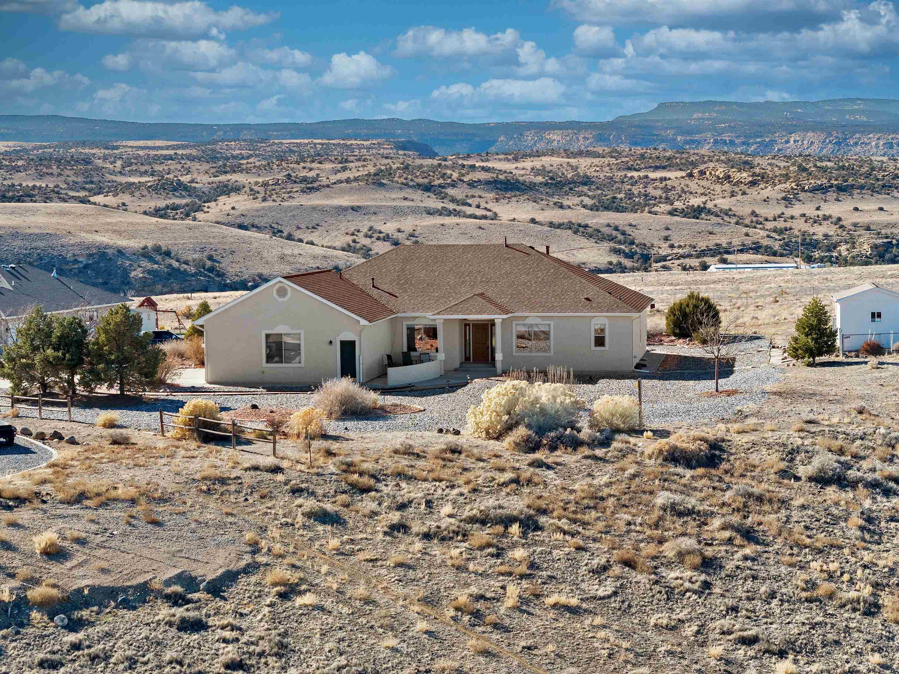 Nestled in the serene community of Whitewater, CO, just south of Grand Junction, this stunning home offers an idyllic blend of beauty, comfort, and adventure. Perched on over 4 acres at the end of a quiet cul-de-sac, this 3-bedroom, 2-bathroom, ranch-style home features a thoughtfully designed open-concept layout with vaulted ceilings, large picture windows, and a split bedroom floor plan. The living room is flooded with natural light and offers unobstructed views of the Grand Mesa, the Uncompahgre and the Bookcliff Mountain ranges.  The formal dining room, perfect for entertaining, captures breathtaking sunrises while the eat-in kitchen boasts solid surface countertops and ample space for culinary creativity. The primary suite is a private retreat with a luxurious 5-piece bath, including a jetted tub, and a spacious walk-in closet. Two generously sized bedrooms, a spacious family room, and excellent storage throughout the home ensure comfort for family and guests. A whole house generator (can be hooked up to solar), a newer HVAC system, newer hot water heater,  and a new roof and stucco this year, ensure year-round comfort and efficiency. Step outside to enjoy low-maintenance xeriscaping, 5-raised garden beds, and abundant outdoor living spaces. Covered patios on both the east and west sides provide perfect spots for morning coffee or evening sunset gatherings while soaking in the spectacular views. The large dedicated RV Parking sits adjacent to the oversized 3-car garage which offers ample space for tools, and toys, making it easy to embrace the area's endless outdoor adventures. This home combines peace, privacy, and practicality.  Whether you’re relaxing at home or exploring nearby trails, this property is your gateway to a life of beauty and adventure.