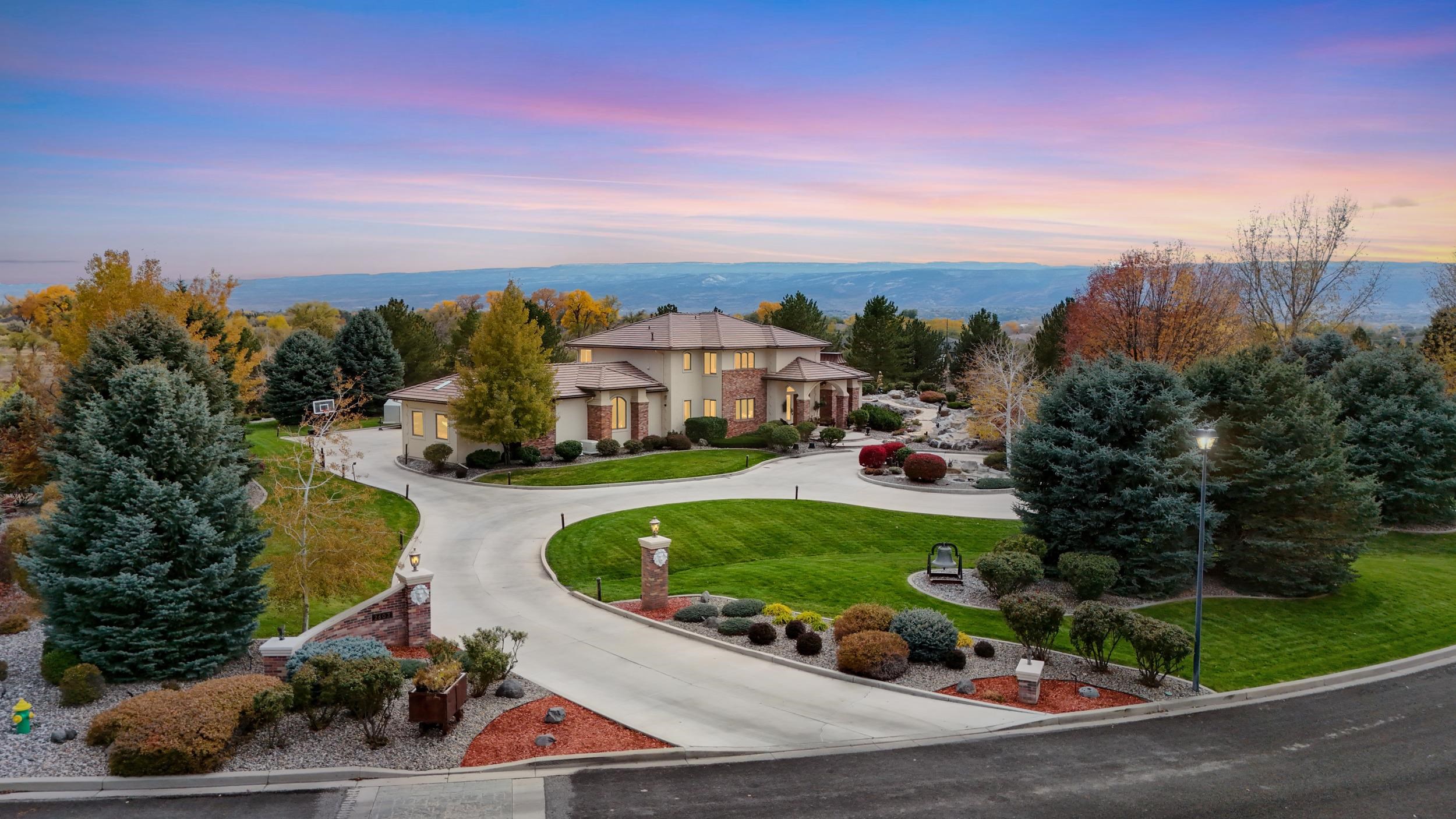 One of Grand Junction's most iconic and notorious homes is now available after an extensive, year-long remodel. As you approach the property, you'll be immediately captivated by the stunning water features that surround this incredible estate. A towering fountain rises majestically from the center of the circular driveway, setting the tone for what's to come. To the west, a mesmerizing river-like fountain flows past graceful dolphin sculptures, winding around the side of the home, flowing under the driveway, and culminating in a breathtaking water display.  Step inside to find a completely renovated main level, featuring luxurious Cristal quartzite countertops and backsplash. The waterfall island, beautifully backlit, serves as a stunning statement piece. Custom cabinetry throughout offers plenty of built-in storage and soft-close features, while the well-appointed kitchen includes a butler’s pantry with abundant storage, picture windows, a full freezer, and a wall oven/convection oven.  The spacious owner's suite is a true retreat, featuring automatic blinds, a double-sided fireplace that opens to both the bedroom and a private courtyard with a hot tub. The custom walk-in closet is a dream, complete with a champagne refrigerator and custom lighting. The ensuite bath boasts beautiful custom cabinetry, a glass-enclosed shower, heated floors, and a bidet for the ultimate in luxury.  The home’s original bar area has been updated with modern lighting and features beautiful engineered hardwood floors, fresh paint, and picture-perfect views. Throughout, you'll find automatic blinds and a fully integrated sound system, extending even to the backyard.  Outside, enjoy the ultimate in luxury living with a saltwater pool that's been fully renovated, including a new heater, pump, liner, and cover. The outdoor kitchen, multiple covered patios, and expansive backyard create the perfect space for entertaining or relaxing in privacy. Fresh lighting and stucco fencing have been added for a sense of seclusion. The property borders HOA common space, further enhancing its sense of privacy and openness.  This one-of-a-kind home blends timeless elegance with modern luxury, offering the perfect blend of comfort, style, and privacy. Don't miss your chance to own a piece of Grand Junction's finest! The lot to the East is NOT included but also available.  NO SHOWINGS UNTIL 1/25/25