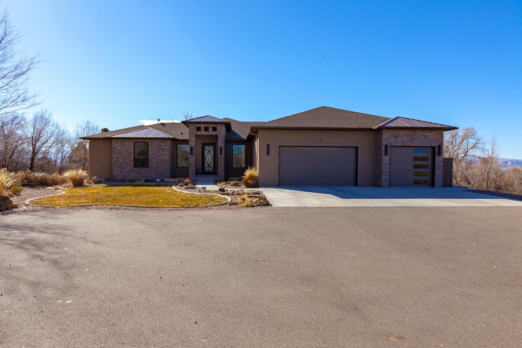 This custom home is a must see! Bright, spacious open concept that features high end materials, energy efficiency and stunning architecture. The custom 9 foot iron front door welcomes you into a grand 14' foyer with impressive steel I-beams and natural stacked stone. Massive picture windows and an expansive deck with views of the Monument, Bookcliffs, and Grand Mesa.  Large primary bedroom with great lighting, walk in shower, huge walk in closet.  Two additional large sized bedrooms on the main level with private bathrooms and walk in closets. The walk out basement has high ceilings with great light, two large bedrooms that share a full bathroom, additional laundry area and an office.  The spacious entertainment room has a wet bar, dishwasher and additional seating.  The multiple areas for entertainment are perfect for large or more intimate gatherings. On just over two acres this home offers the privacy you are looking for.