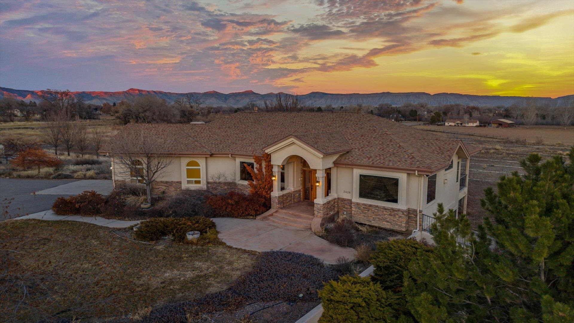 Nestled amidst the serenity of Grand Junction, Colorado, the 22-acre estate at 2426 H Road offers an unparalleled blend of tranquility and potential!  The property's vast acreage presents a canvas of possibilities. Panoramic views and expansive grounds offer a peaceful setting ideal for a relaxing lifestyle. For the visionary, this estate provides the perfect backdrop to craft a private golf course, where rolling greens meet the horizon, offering both recreation and seclusion in an extraordinary setting. With its natural elevation changes and stunning vistas, the land could be transformed into a golfer’s paradise, complete with fairways that blend seamlessly into the landscape, a personal putting green, and even a clubhouse-style retreat.  Alternatively, the property’s sprawling acreage is well-suited for an equestrian estate. Picture riding across open pastures with breathtaking views of the Grand Mesa and Mount Garfield in the Alpenglow of the Western Slope Sunsets, training in a custom-built arena, or designing a luxury barn with spacious stalls, a tack room, and riding trails winding through the property. Whether you dream of hosting equestrian events, building a state-of-the-art training facility, or simply enjoying the elegance of a horse property, this estate offers limitless potential to bring your vision to life.  If developing the property is of interest, this property is in the county, adjacent to, but outside the Persigo boundary.       The existing home was built in 2001 with attention to detail, and quality craftmanship.  The expansive 3,818-square-foot residence features three spacious bedrooms, an office, two living areas, two and a half bathrooms, numerous outdoor living areas, and tremendous views, providing ample space for both personal enjoyment and relaxation, and for entertainment.  The 50x30 shop at the north of the property lies north of the Grand Valley Irrigation Canal, and is accessed via a bridge designed for heavy equipment.          Located just north of Grand Junction with quick access to local hospitals, services, shopping, entertainment and restaurants, this estate combines the allure of secluded country living with the convenience of nearby urban amenities. Whether you envision a tranquil retreat, a golfer’s paradise, a horse lover’s dream, or a development, 2426 H Road stands ready to fulfill your aspirations.  All information subject to change/error, buyer to verify all information.