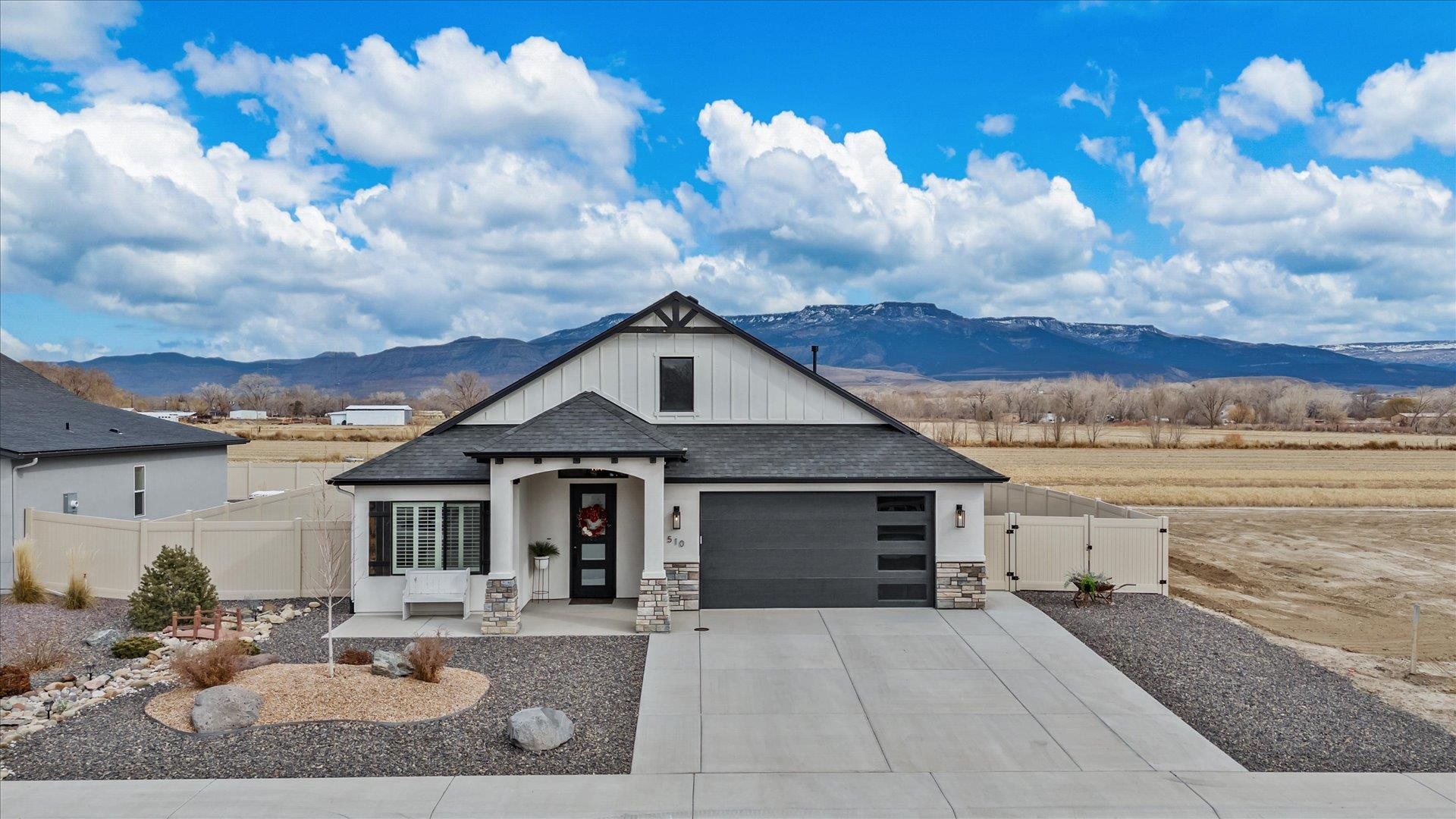 Better than new! Discover a 4-bedroom, 2-bath home built in 2022 by Alta Home Builders that truly exceeds new construction standards. Spanning 1,801 square feet, this residence features an open, split-floor plan with vaulted ceilings and luxury vinyl plank flooring.   Enjoy captivating panoramic views of the Grand Mesa from nearly every room, framed by a sleek black-and-white exterior blending stucco, wood, and cultured stone.  The gourmet kitchen boasts stainless steel appliances, a gas range, built-in microwave, and a kitchen sink with a touch sensor faucet. The spacious primary suite offers a generous walk-in closet and an en-suite bath complete with a walk-in shower and premium fixtures.  Bonus: a lighted attic with finished flooring provides extra storage.  Outside, a landscaped front yard and an extended back patio create an ideal setting for entertaining, while energy-efficient upgrades—such as Energy Star windows, high-efficiency lighting, and a programmable thermostat—ensure year-round efficiency.  Schedule your private tour today!