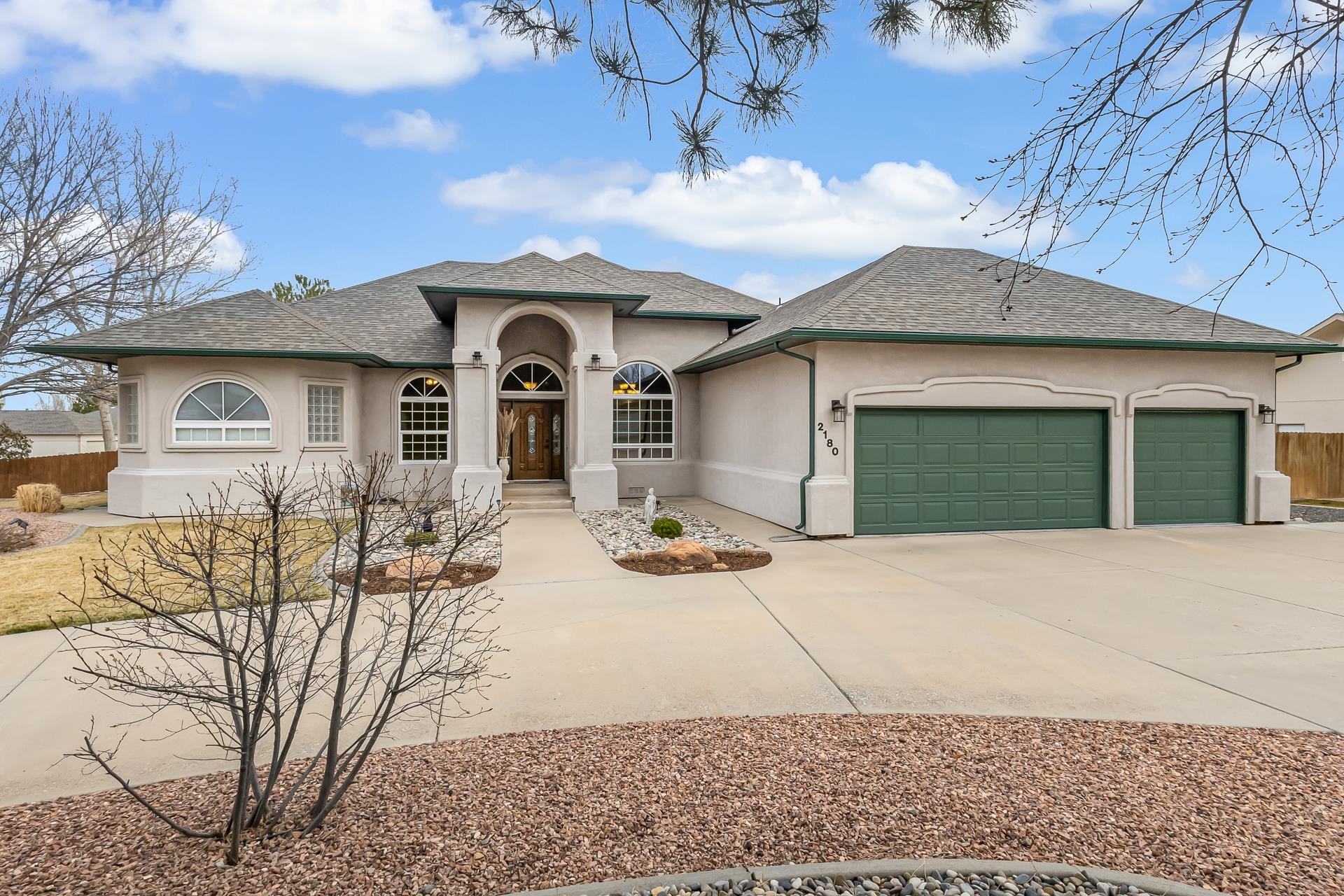 Welcome to this well-maintained, ranch-style home with beautiful views of the Colorado National Monument. This home features four spacious bedrooms and three full bathrooms. Vaulted ceilings throughout enhance the open-concept design, creating a comfortable and airy feel.  Large windows fill the home with natural light and offer great outdoor views. The living areas feel fresh and welcoming, perfect for relaxing or entertaining. Recent updates, including new flooring, carpet, and paint, make this home move-in ready.  Step inside through the new front door to find updated features from baseboards to overhead lighting. Each bathroom has been improved with modern fixtures, and the five-piece master bath includes a new granite countertop with dual sinks and a jetted tub. The spacious master bedroom also offers his-and-her walk-in closets.  The dining area is ideal for both large family dinners and smaller gatherings. A large laundry room provides added storage. The oversized three-car garage offers ample room for vehicles and gear, while RV parking and a new shed provide extra space for outdoor equipment.  The back porch/covered patio is great for barbecues or relaxing while taking in the Monument views. The spacious backyard offers room for children to play and includes a garden area for those with a green thumb.  Situated on nearly half an acre, the property is surrounded by mature trees and shrubs that add character and privacy. An efficient irrigation and sprinkler system simplifies yard maintenance.  This immaculate home offers comfort, functionality, and stunning natural scenery. Schedule your tour today and see what makes this Redlands property special.