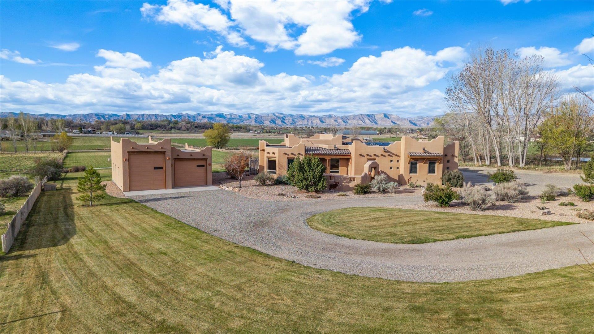 Welcome to 1772 Waters Lane, where custom craftsmanship meets the rugged beauty of Western Colorado. This custom built home by Maves Construction, is perched on 3.4 acres of exceptional property that offers unrivaled panoramic views of the Bookcliff mountains, the Grand Mesa, and the majestic Colorado National Monument - a daily backdrop that’s nothing short of breathtaking.  Built in 2007, this home features an open floor plan with rich Alderwood doors and cabinetry, granite countertops, and exposed wooden beams for a warm, rustic touch. The chef’s kitchen flows seamlessly into the living and dining areas, perfect for entertaining or quiet nights in.  The spacious primary suite offers a peaceful retreat filled with natural light. Step outside to the back patio, where a hot tub pad and porch swing invite you to relax and take in the views—whether it’s sunrise coffee or stargazing under the Colorado sky.  An oversized 3-car garage includes a 12 x 15 separated workshop with a half bath, and plumbing set up with hot and cold faucets for a custom dog wash.   Need more space? A 40’ x 36’ RV shop with 2 240 outlets provides room for all your toys and tools.  Energy-efficient with geothermal heating/cooling and a recirculation pump, solar panels, and central vacuum, this home blends comfort with sustainability.   Located just 5 miles from the renowned 18 Road mountain biking trails, adventure is always close to home.  This is more than a house—it’s a lifestyle. Come experience the best of Western Colorado at 1772 Waters Lane.