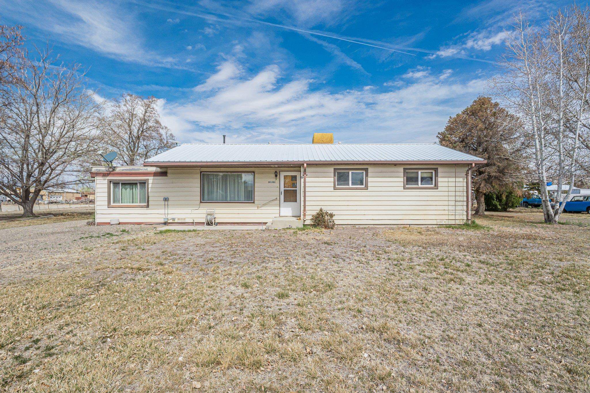 Charming 3-Bedroom Home on 1.82 Acres with Shops & Development Potential. Don’t miss this unique opportunity to own a well-maintained, vintage-style home on nearly 1.82 acres of flat, usable land. This 3-bedroom, 1-bathroom property has been thoughtfully cared for and includes recent upgrades such as a tankless hot water heater and updated windows. Beneath the carpet, you’ll find original hardwood floors just waiting to be uncovered and restored. The true value lies beyond the walls—with multiple outbuildings and room to grow. A spacious 40x30 shop features two 8-foot doors and a 14-foot RV door, ideal for storage, hobbies, or a home-based business. Additional amenities include a second detached shop, a tack shed, two storage sheds, and a drive-through car canopy. With the potential to split the lot (buyer to verify with Mesa County), this property offers multiple avenues for future development or expansion. Enjoy peaceful country living just minutes from town, with space, flexibility, and opportunity in every direction.