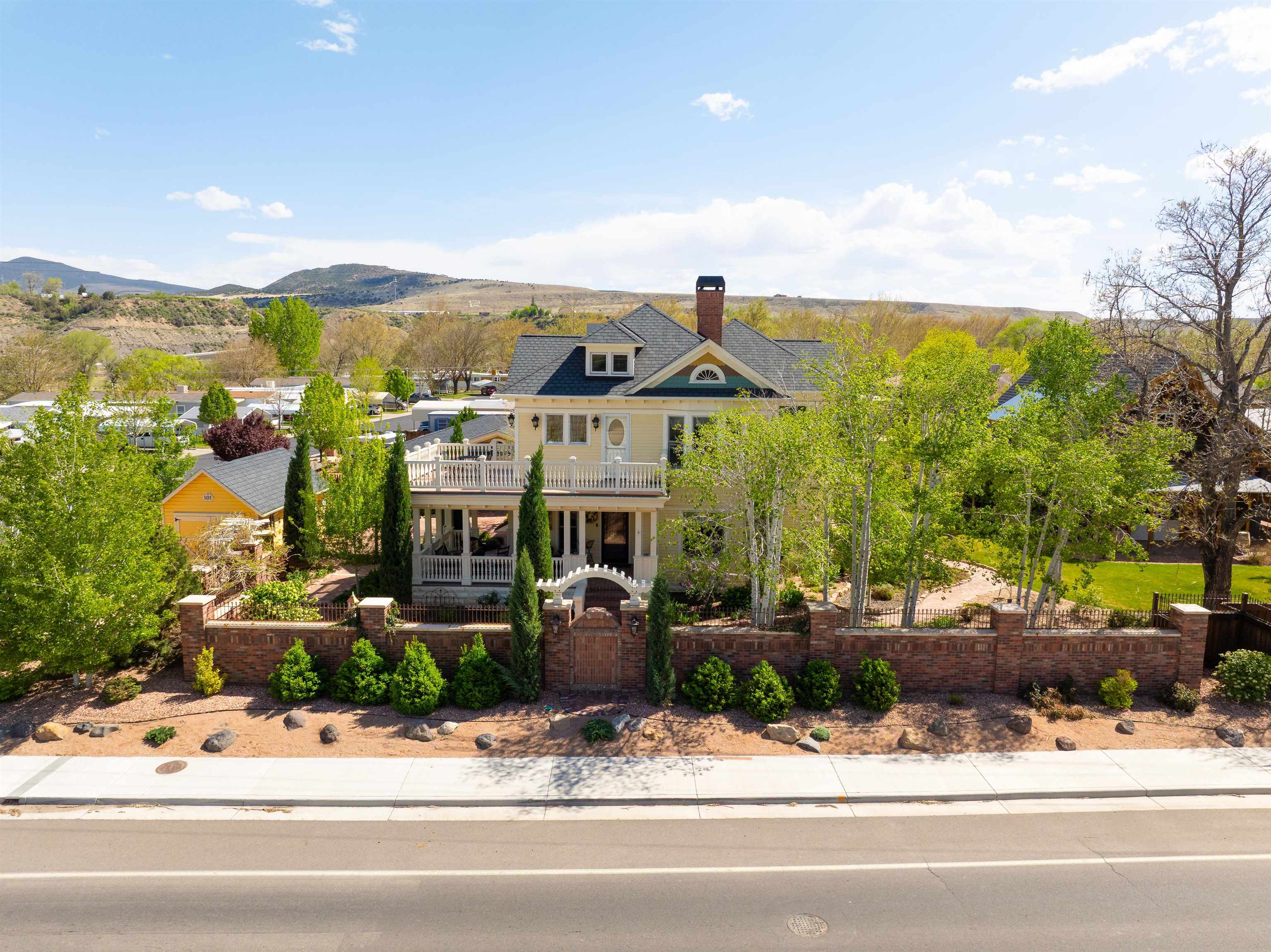 Located in beautiful Palisade, Colorado, this remarkable property blends historic Victorian charm with modern amenities, creating a versatile space that can cater to various needs. Originally built in 1906 this home underwent a meticulous renovation beginning in 2007. The renovation was designed to maintain the home's historic character while integrating modern conveniences which include new plumbing, electrical, HVAC, solid doors, double hung Marvin wood windows and 50-year shingles. The main home features a timeless kitchen with Wolf and Sub-Zero appliances, multiple dining and living options and extraordinary attention to detail.  Upstairs is complete with a well thought out Primary Suite, 2 additional bedrooms, a tranquil nook, loft and dual patios. The expansive grounds span just over an acre and include brick walkways, multiple patio areas, lush landscaping, wrap around porches and a carriage house all with stunning views of the Bookcliffs and the Grand Mesa. A quaint guest house and must-see barn with 2 bathrooms, loft and a large entertaining space round out the living spaces of this enchanted property. With covered RV parking and hook ups, an oversized 3 car garage and various storage options throughout the property, the possibilities are endless. Palisade is a vibrant community know for it's wineries, orchards and close proximity to the Colorado river. It hosts various community events, farmers' markets and cultural festivals, enriching the local lifestyle and offering opportunities for social engagement. Schedule your private showing today!