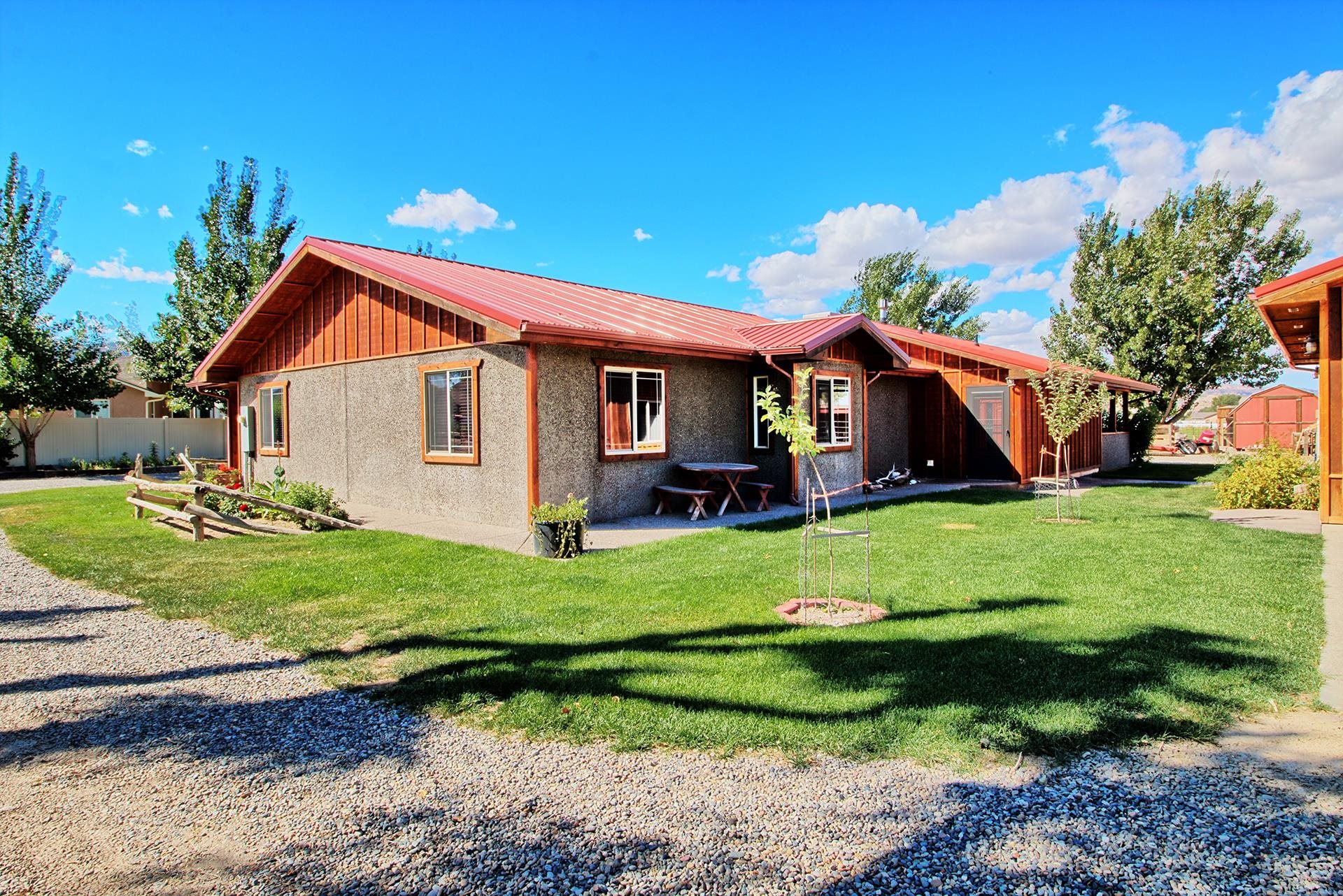 Check out this incredible property located just minutes from the heart of downtown Fruita! The home features a large living room with a wood stove to keep you warm on those chilly nights and beautiful heated-stamped concrete flooring throughout the home.  The kitchen highlights spacious hickory cabinets and a newer gas stove. The knotty pine doors and wooden beams accents, and cozy window seat give this home a very luxurious feel. Some of the walls of the home are built with a 10" Superior concrete wall system for outstanding insulation qualities. Outside the home you will find a beautiful pasture with corrals and loafing sheds, a chicken coop, 2 storage sheds, an oversized garage/shop with covered outside storage, a 12X30 hay/RV storage shed, garden area, and beautiful landscaping.  3 shares of irrigation water are also included.  Development opportunities may also be available.   Schedule your showing today!!