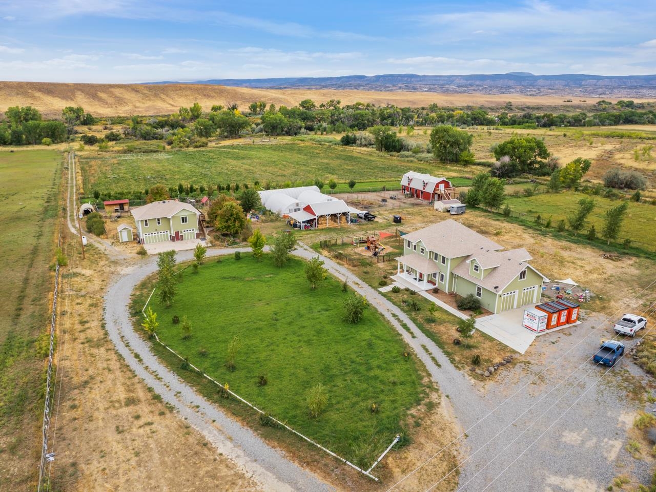 Welcome to this extraordinary estate in Whitewater, Colorado, where rural charm & modern luxury seamlessly blend on over 20 acres of land. Nestled against the backdrop of the awe-inspiring Grand Mesa & Uncompahgre Plateau, this property is a testament to Western Colorado's natural beauty. The main residence spans 5,372 square feet, with 2 stories & a fully finished basement. This home offers spacious living areas, including 5 bedrooms & 4 bathrooms. Inside you’ll find hardwood floors & granite countertops with stainless steel appliances in the kitchen. Natural light pours in, & you’ll enjoy having 2 separate living spaces, an office, a game room, a sunroom, & a large storage room in the basement. The attached 2-car garage provides convenience & additional storage. Additional features include 2 heating and cooling units for optimal comfort & a tankless hot water heater. There's even potential to add a kitchen to the basement. The accessory dwelling unit (ADU) is a 1,029 square foot space, offering 2 bedrooms, 1 bathroom, & a charming living space. Perched atop a spacious 3-car garage, the ADU boasts a beautiful deck overlooking the property. Electric & water meters are separate from the main home & this space is also outfitted with a tankless hot water heater. This property is a dream for those seeking an outdoor lifestyle. It boasts a 4-stall horse barn with an unfinished loft, tack room, & separate building for hay storage. 3 generous greenhouses are perfect for gardening & farming enthusiasts. Additionally, there's a dog run, goat pens, a chicken coop, & a fenced play yard. There's an extra outbuilding & an apiary for beekeeping enthusiasts. 2 storage sheds offer plenty of room for tools & equipment. The front & side yards are beautifully landscaped with mature trees & bushes, while the property features an orchard & fields for agricultural pursuits. A highlight of the property is its access to Kannah Creek, where a yurt sits on the waterfront, providing a unique space for gatherings & there is a small stage for performances. With 15 acres of irrigated land & no HOA restrictions, you have the freedom to bring your vision to life. There's plenty of space for RV parking, making it convenient for your adventure plans. Situated just outside the bustling city of Grand Junction, Colorado, this property offers a tranquil retreat while still being close to all the amenities & outdoor activities that define Western Colorado living. Welcome home to Whitewater, CO.