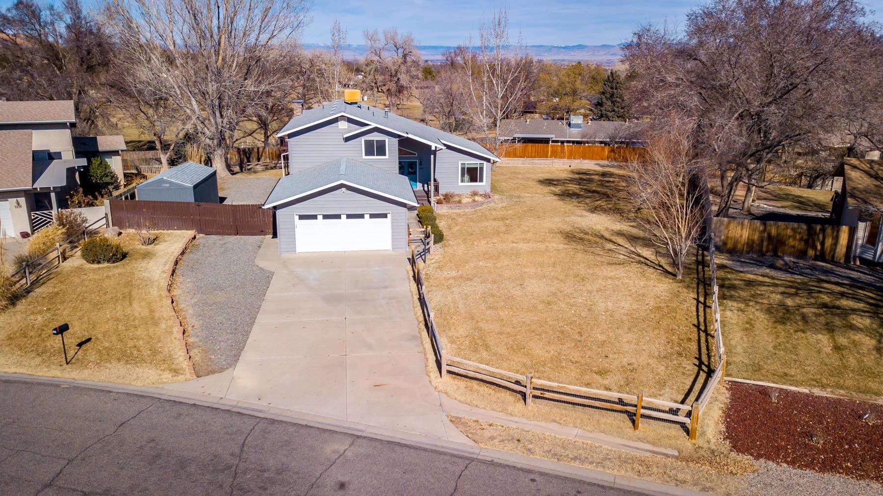 Take a look at this incredible home in a fantastic location. There is so much to appreciate about this Redlands gem, with too many improvements to list, please come take a look at this one yourself. The views of the Colorado National Monument are jaw dropping, from the second story deck you can see for miles. Open and bright as you enter the home, vaulted ceilings and ample windows (2018) let all the natural light pour inside. Extensive counter space and cabinet storage in the updated kitchen, all appliances stay. Bonus spaces abound in this home with a separate dining area, family room with new gas fireplace, and office upstairs. Primary bedroom with ensuite 3/4 bath and walk in closet is upstairs, along with two additional bedrooms and a full bath. The largest bedroom is on the main level and has convenient access to the nearby 3/4 bath and laundry room. The entire yard is enclosed with either a cedar split rail fence with welded wire (2022) or the adjoining privacy fences. Take advantage of additional outdoor storage with RV parking and a new 10 X 20 shed (2022). Irrigation system has been overhauled with new pump and display box in 2021 and new electrical box in 2023.