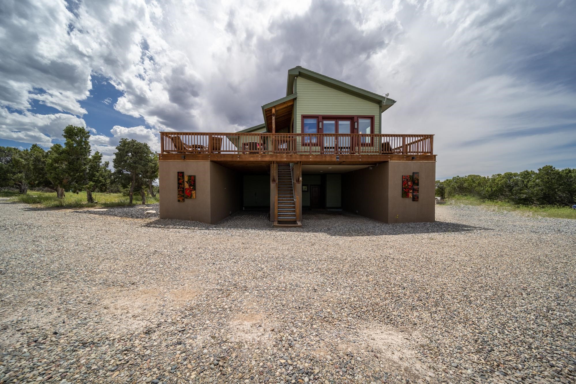 Welcome to Isle in the Sky!! A beautiful 30-minute drive from Grand Junction, CO. There are so many unbelievable features to this property you will need to see to truly understand and appreciate. Please reach out to get a full list of details on this property, including plans to add additional living space in garage/shop. As you enter the drive up to the home you will pass a large meadow that Elk love to visit. This meadow will also accommodate St. Mary's Flight for Life Helicopter that could be to you within 5 mins to rescue if needed. This home was built over 8 years, the majority of it completed in 2023. The designers of the home took the approach of bringing the outdoors in! You will notice this with large windows throughout, vaulted ceiling and ideally placed French doors. Living space and studio is on the 2nd floor with 360-degree panoramic views. Elevator, which will accommodate electric wheelchair, ensures that everyone will be able to enjoy this home. Just some of our favorite features are beautiful quartz counter tops from Peru, stunning rock wall with lit niches, live edge wood framing, hanging pendants wall sconces and decorative lights throughout and stained concrete floors with radiant heating. Don't miss the custom designed portable island complete with locking casters to match the kitchen. Attention to detail and efficiency of space is seen throughout this home. Raised wrap around deck gives you space to entertain with hot tub, fire pit (piped to propane tank), grill (also piped to propane) and enjoy the views. Property features a 4-bay shop/garage complete with a "cleanroom", half bath and small office where security system connects. Advanced state-of-the-art technical equipment runs this home (please call for list). Surge protector at electrical box cleans power before entering the home. Wiring and plumbing are fished through conduit. Exterior has an outdoor shower with both hot and cold. RV hook up and parking also in place with 220 electrical from shop. Well, cistern and septic were all designed large enough to accommodate another home to be built on the property. Endless potential with this unique retreat!