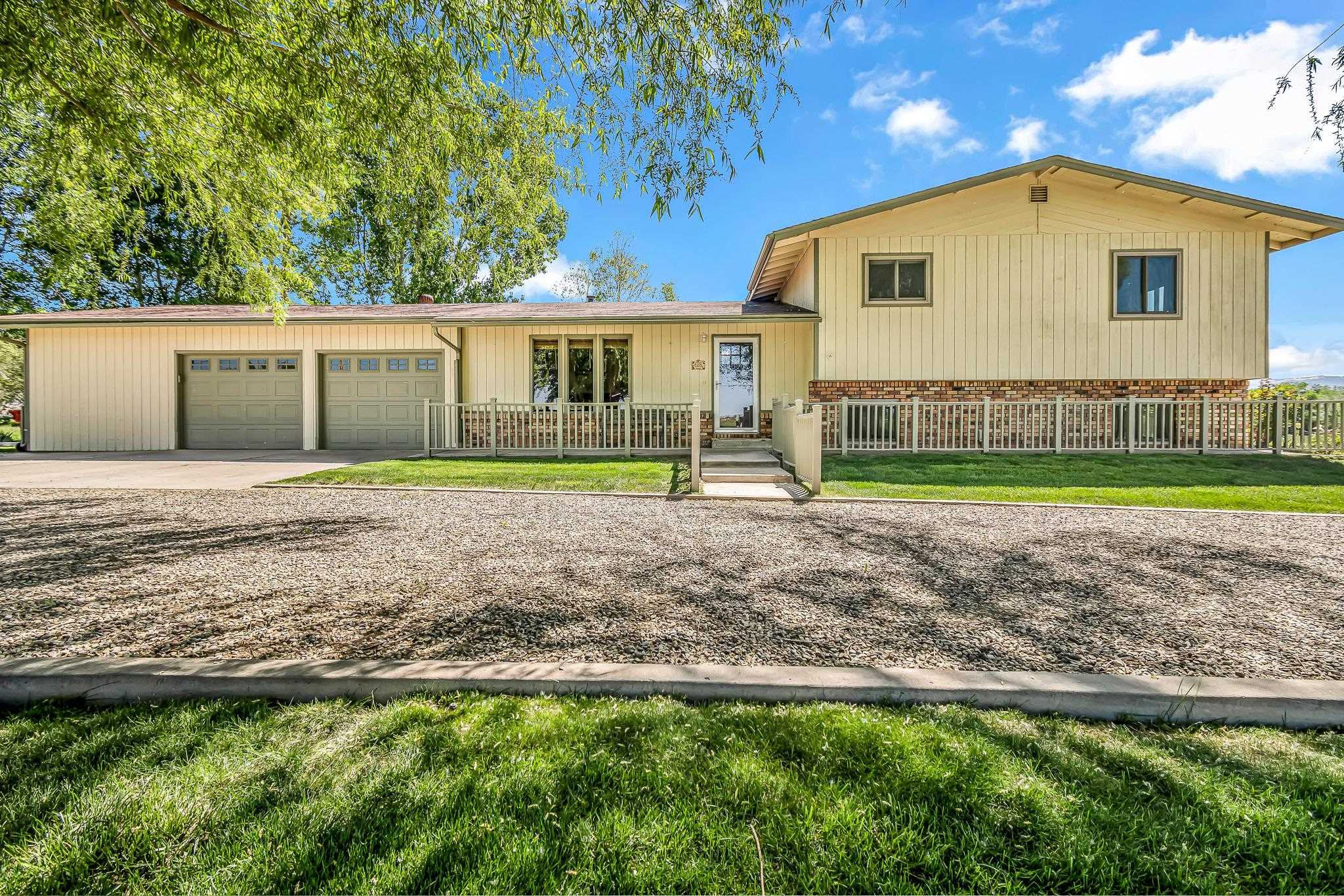 This 4-bedroom, 3.5 bathroom home is located on 9.57 acres in the heart of the Mesa County’s agricultural mecca near Palisade. The home is a 2304 sf, tri-level design that was built in 1977 with unprecedented views of Grand Mesa.  The recently remodeled kitchen’s cute farm style design includes granite countertops, double ovens, gas cook-top, wine fridge and a large pantry area. There are two separate living areas – one on the main floor as you enter the home and the second is in the lower part of the home. Large windows (new in 2022) are found throughout the home allowing for maximum natural light throughout. Flooring includes hardwood, carpet and tile. There is an oversized 2 car garage attached to the home with a large storage area, ½ bath and office area.  Step outside onto the east facing patio with a new louvered pergola for relaxation and enjoy beautiful views of Grand Mesa and Mt. Garfield.  There is a 30’ X 50’ metal garage / workshop with an RV hookup. A large 50’ long covered carport area alongside the exterior of the garage works perfectly for either hay storage or as a covered area to park an RV. The property was previously home to an Alpaca farm. Although the Alpaca farm is no longer in business, the property is still set up with an arena area. The panels have been removed so the new owner would need to replace the panels. Potable water is available to allow for fresh water to be delivered within the arena / corral area. There is no HOA and livestock are allowed on the property. A chicken coop that currently houses 5 hens is also included. The grass hay that is grown on the property is a high quality variety that is perfect for alpacas and horses alike. The owners currently get 3 cuttings a year with an approximate yield of 550– 600 bales. The bales are approximately 75 lbs each and are selling this year for $9 each. The field has been maintained with proper fertilization and a neighbor processes (cuts, bales and stacks) the hay for each cutting. There is gated pipe that is included in the purchase price. The property has approximately 10 shares of Price Ditch water that is delivered to the property. The cost for the irrigation water is assessed thru the annual property taxes. The property is zoned AFT. It is not common to find a quality property of this size available anywhere in the Grand Valley area, let alone in such close proximity to Palisade.