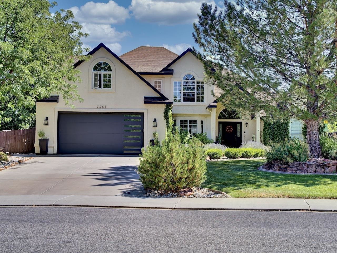 This luxury 4-bedroom, 3 bath home boasts an impressive half-acre lot with meticulously maintained mature landscaping, offering both privacy and natural beauty. The property is designed to impress with exceptional finishes throughout, blending elegance with modern comforts. Centrally located less than 5 minutes from St. Mary's Hospital and downtown Grand Junction! The gourmet kitchen is a chef's dream, equipped with high-end appliances including a JennAir Gas Cooktop and custom cabinetry. The home features multiple living spaces, including a cozy family room with a fireplace and a sunlit sitting area overlooking the lush backyard. Large windows with custom window treatments invite natural light to flood the interior spaces while offering stunning views of the outdoors. Many areas of the home also have in-floor radiant heat. The luxurious master suite is a sanctuary unto itself, boasting a spa-like ensuite bathroom which is sure to impress. Three additional bedrooms offer comfortable accommodations for family and guests. The outdoor living area is a true retreat, featuring a sprawling patio with Trex Decking, manicured yard complete with a sprinkler system and a firepit. Whether hosting summer barbecues or enjoying quiet evenings under the stars, this backyard paradise provides the perfect setting for relaxation and entertainment. The garage has built in custom storage spaces and epoxy floors. Additionally, there are 2 sheds to provide all the space you need for your toys! Don't miss your opportunity to own this stunning property!