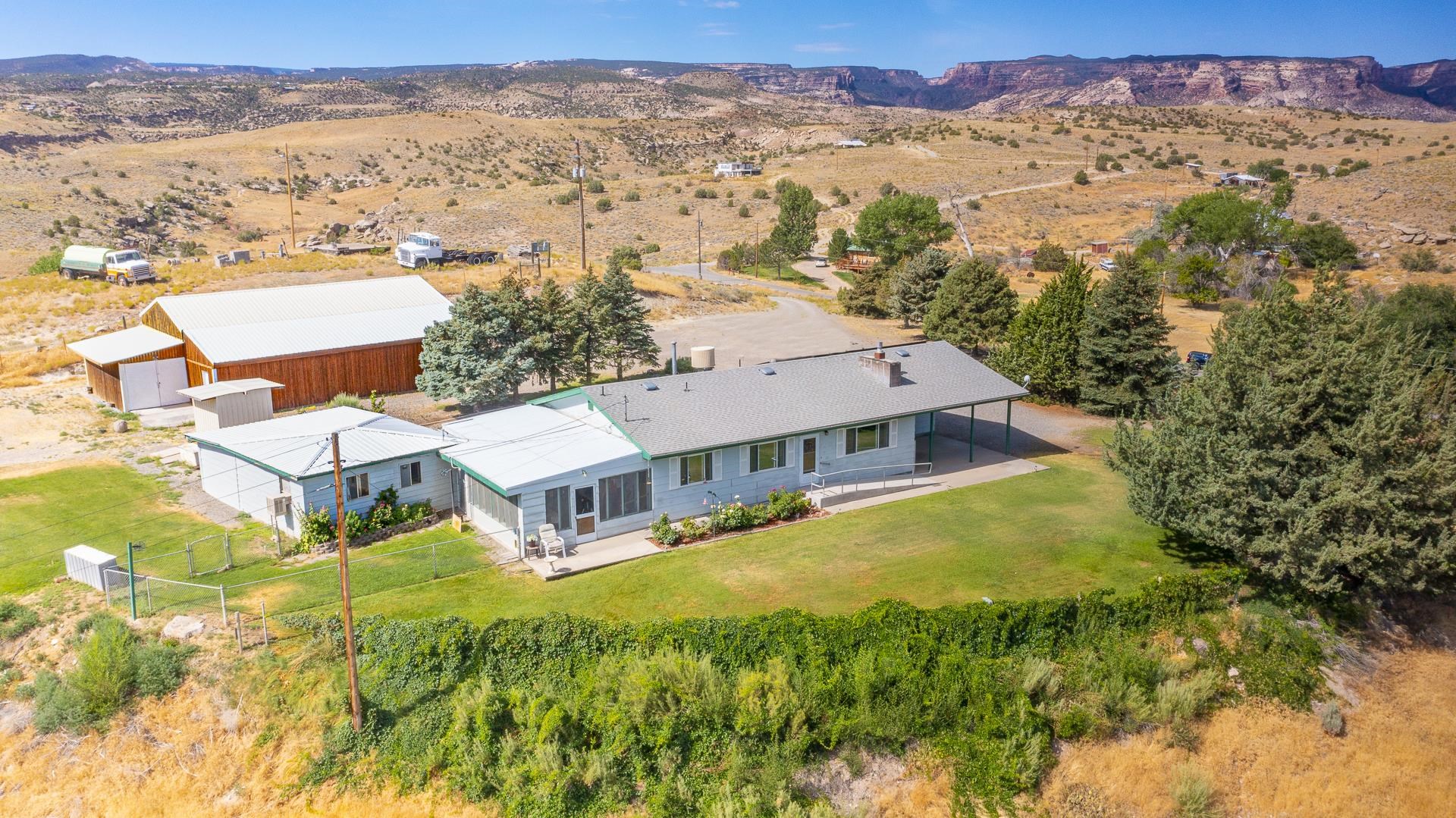 This is the rare Redlands gem you've been waiting for! Perched on its own private plateau above the Grand Valley, this home epitomizes Western Colorado lifestyle at its finest. If you're looking for close proximity to recreation, take a short 2 minute bike ride out of your front door to the end of Mira Monte Road. You'll find yourself at the Lunch Loops Trail System, one of the most popular trail networks in the Grand Valley. Direct access to this trail system is something that doesn't come available often! Only a five minute drive will also take you to the heart of Main Street. This location truly offers the best of both worlds. If you need room for toys and hobbies, you'll find a large 48 X 37 barn, large enough to store RV's, one-car garage, carport and two additional workshop areas. The tranquil grounds are also sprinkled with evergreen trees, grassy lawn areas, and an amazing covered patio. This is the perfect basecamp for anyone who loves recreation or perfect for someone looking for their private hilltop abode up above the stunning backdrop of the Grand Valley. The well-maintained home itself is highlighted by a functional floorpan with spacious living areas, a fireplace and plenty of windows. Offering some of the most incredible views in Grand Junction, ample amenities, privacy and space, all nestled in the perfect location, you won't want to miss out on this opportunity!