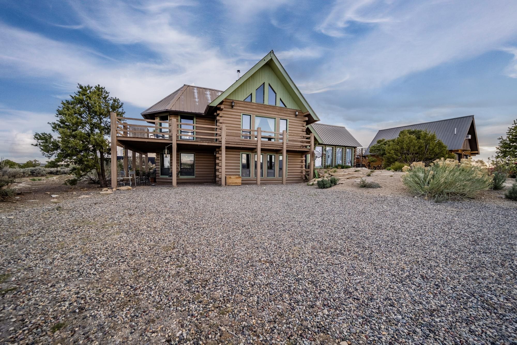 A beautiful log home set on 35 acres of sprawling land and forest, just 25 minutes from Grand Junction, with stunning views expanding from Mt Garfield in Palisade to the La Sals in Utah. The property is surrounded by wildlife and features 4 possible bedrooms in the main house, a studio caretaker Accessory Dwelling Unit (ADU) above the garage with income producing opportunity, a 2-car detached garage, owned solar, shed, and workshop with electricity. 10 of the 35 acres are fenced for livestock. Seller is willing to include a 2022 Kabota tractor with attachments, dog kennel and some furnishings with sale of property! The home is a perfect blend of rustic charm and modern amenities providing you with the best of both worlds! Find your inner peace amidst the serene surroundings.