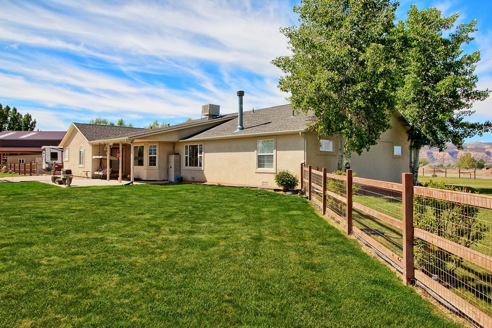 ** New Roof is being Installed** Makes this home an even better value + $10,000.00 credit to Buyer for updates, closing costs or interest rate buy-down, with an acceptable offer. Home Warranty is also included! You can have it all! Acreage-3.22 with irrigation water. Property includes the field to the north-not just the landscaped yard.  RV Garage- 30x40 with 220. RV parking +Storage-multiple out buildings for storage options, great small workshop for hobbies or use as a garden/potting shed for all your gardening. Mature landscape, lush grass, mature trees, beautiful flowering shrubs and plants +raised garden beds. Gazebo seating by the beautiful pond with fountain. Covered front and back porches to enjoy the views of Colorado National Monument, The Bookcliffs and The Grand Mesa. Beautiful Home- Yes Indeed! Large rooms, great floor plan and ample storage throughout. Formal dining, breakfast nook overlooking the beautiful yard. Well-appointed kitchen with cherry cabinets, lots of counter/workspace and two pantries. Large living area with fireplace, 2 large bedrooms with adjoining bath and an office. Large primary suite features a spa like ensuite with jetted tub. Plantation shutters, cordless wood blinds are just a few of the extra features. New hot water heater in 2022, new dishwasher 2023. If property is annexed into City of Fruita, potential to split off 1 acre parcel +/- and sell or have family build next door. This has everything that you want and MORE!